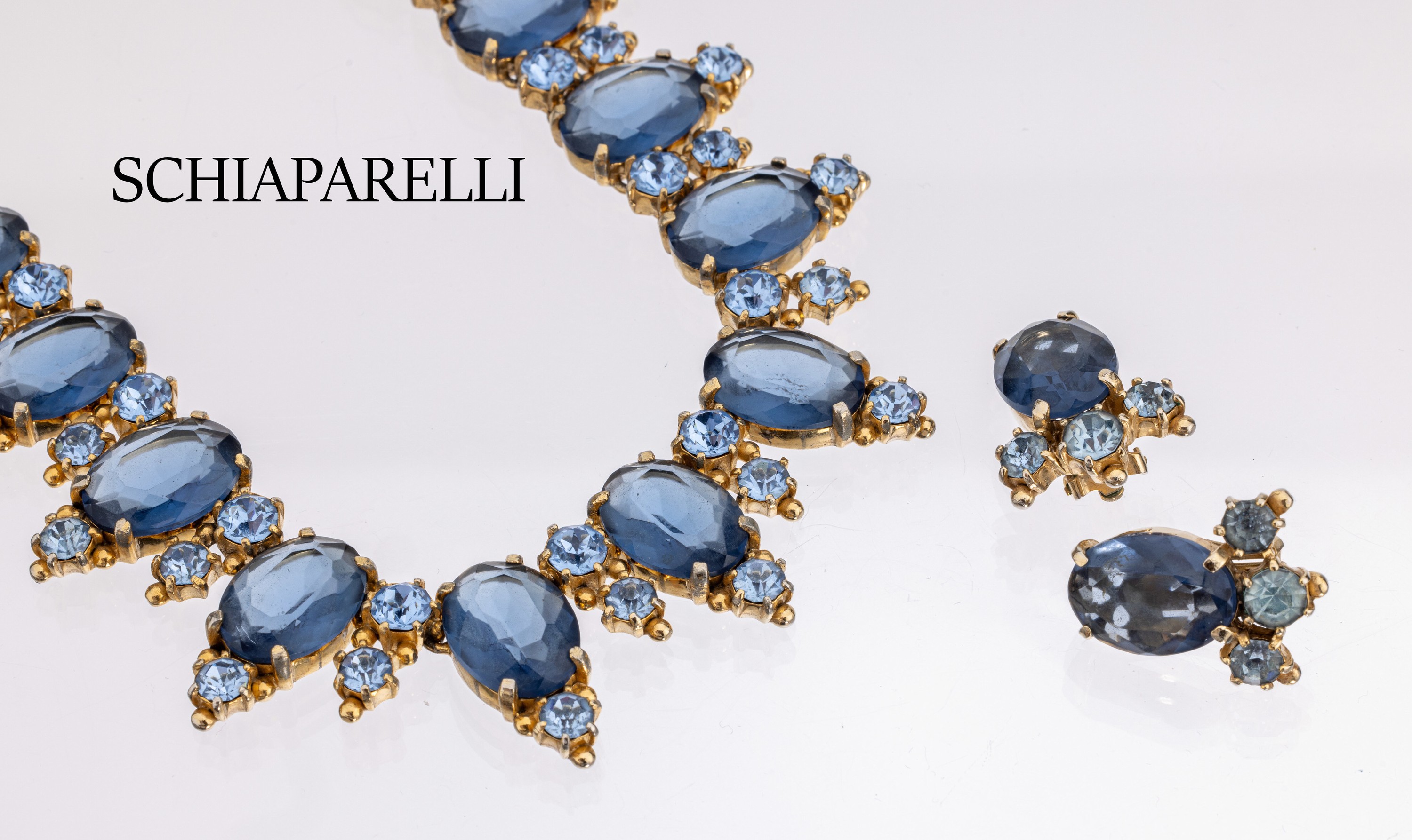 SCHIAPARELLI Schmuckset, Metall verg., USA um 1955, best. aus: Collier, L. ca. 39 cm, Hakenschliesse, und 1 Paar Ohrclips, Besatz mitsaphirfarb. ...