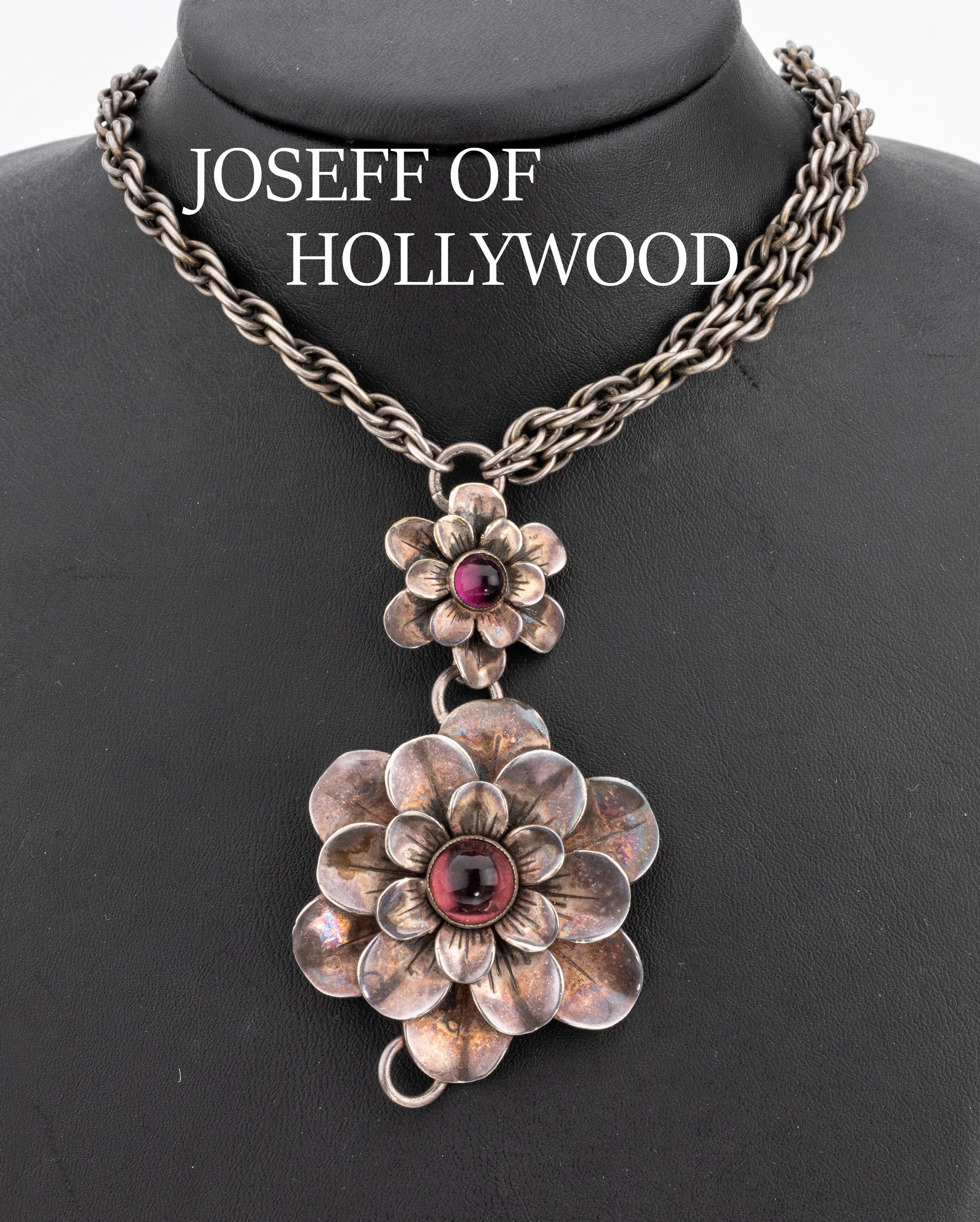 JOSEFF of HOLLYWOOD Blüten-Collier, USA um 1960, Mittelteil mit 3 plastischen Blüten, mit3 amethystfarb. Cabochons, L. ca 40 cm, Hakenschliesse, ...