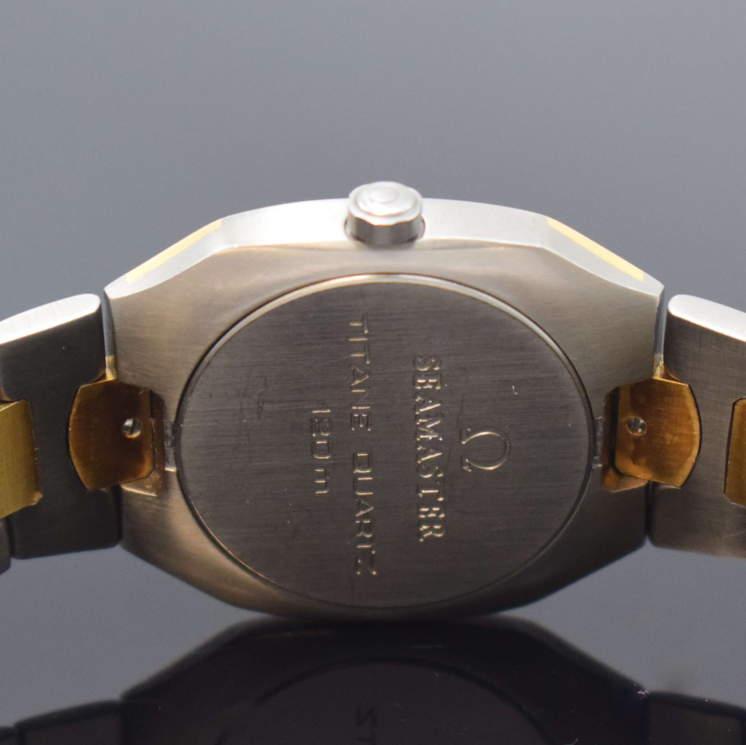 Detail d: OMEGA Seamaster Polaris Armbanduhr in Titan/Gold, Schweiz um 1990, quarz, intarsierte Lünette sowie Zwischenglieder in GG, Faltschl., graues ...