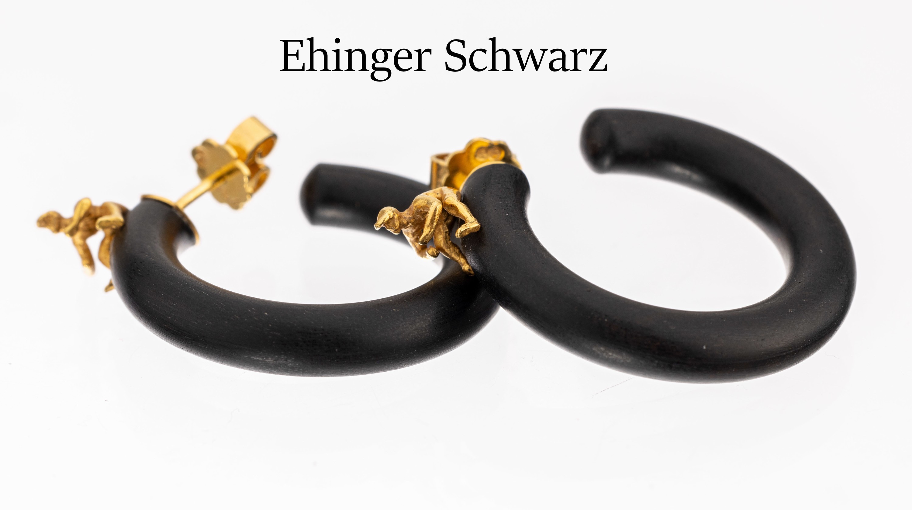 Paar Ehinger Schwarz Ebenholz Creolen, GG 750/000, Ebenholzcreole, oberhalb in GG sitzen-der Mann, plastisch, Brisuren in GG, D. ca. 2.5 cm, sign.