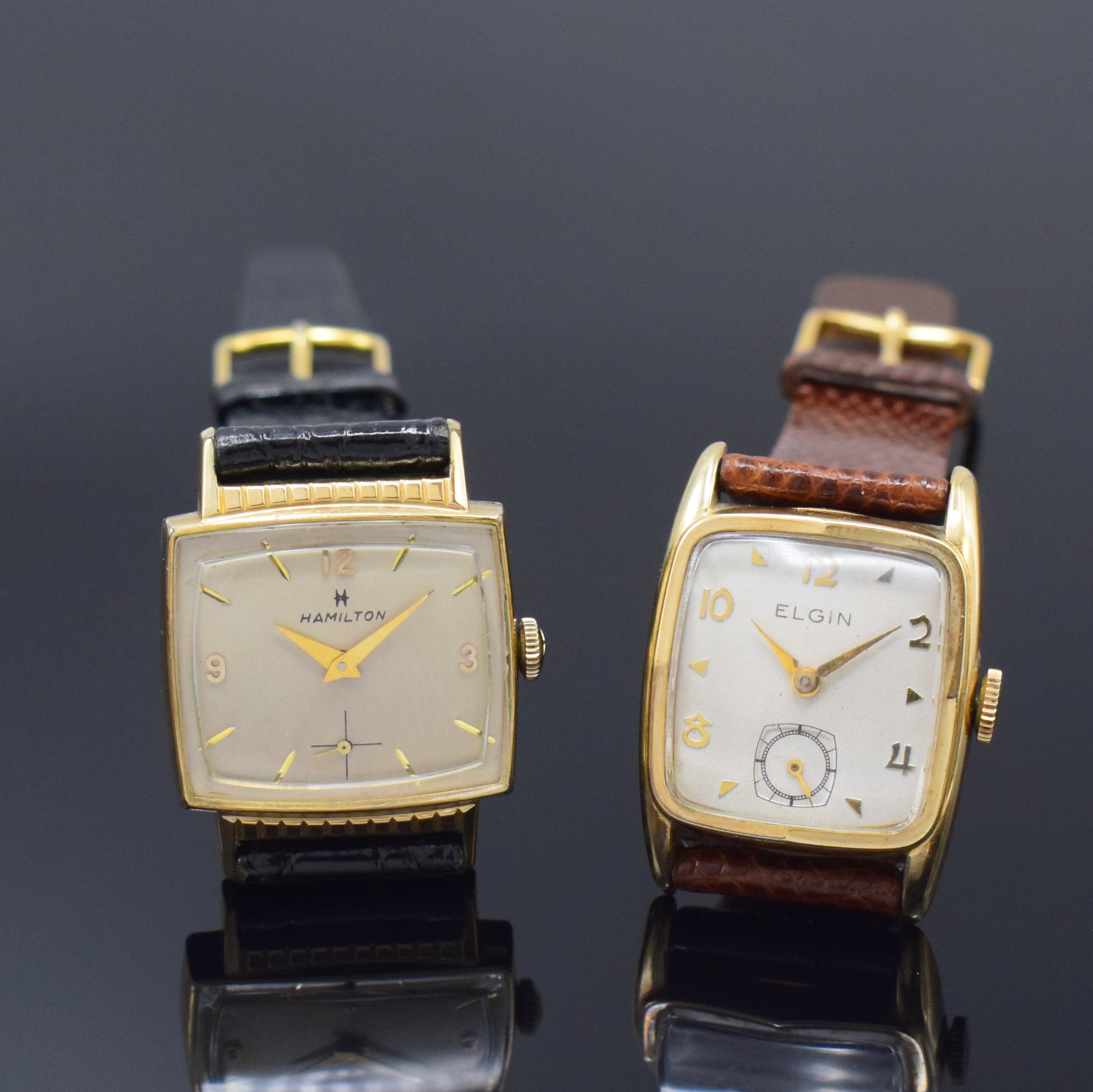 ELGIN und HAMILTON 2 vergoldete Armbanduhren, Schweiz/USA 1945, Handaufzug, Stahlböden aufgedr., vers. Zifferblätter m. gold. Std.-Indizes u. arab. ...
