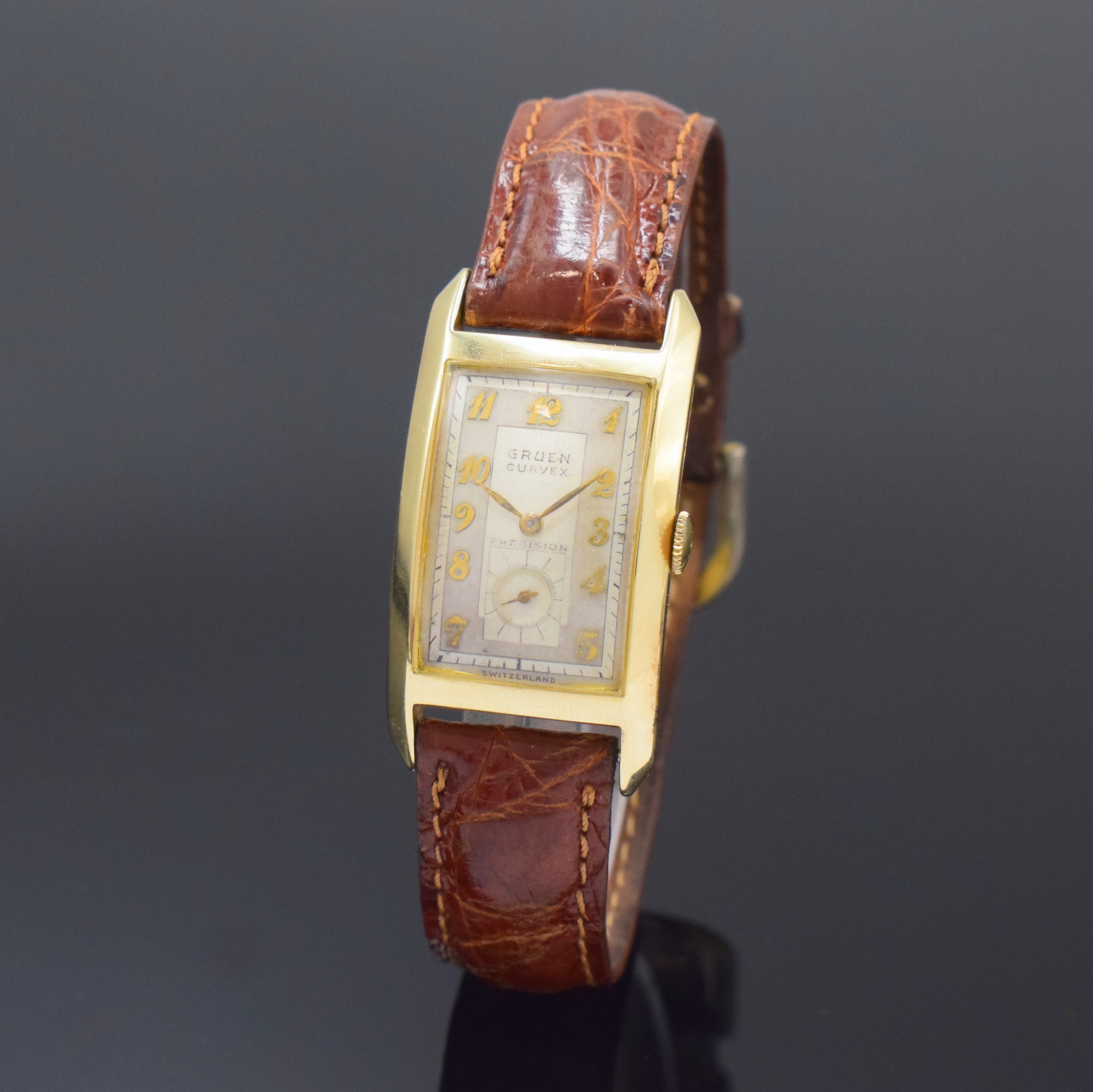 GRUEN Curvex Armbanduhr in GG 585/000, Schweiz fürUSA um 1940, Handaufzug, Boden aufgedr., silb. Zifferbl. m. arab. Zahlen, gold. Zeiger, sign. Werk ...