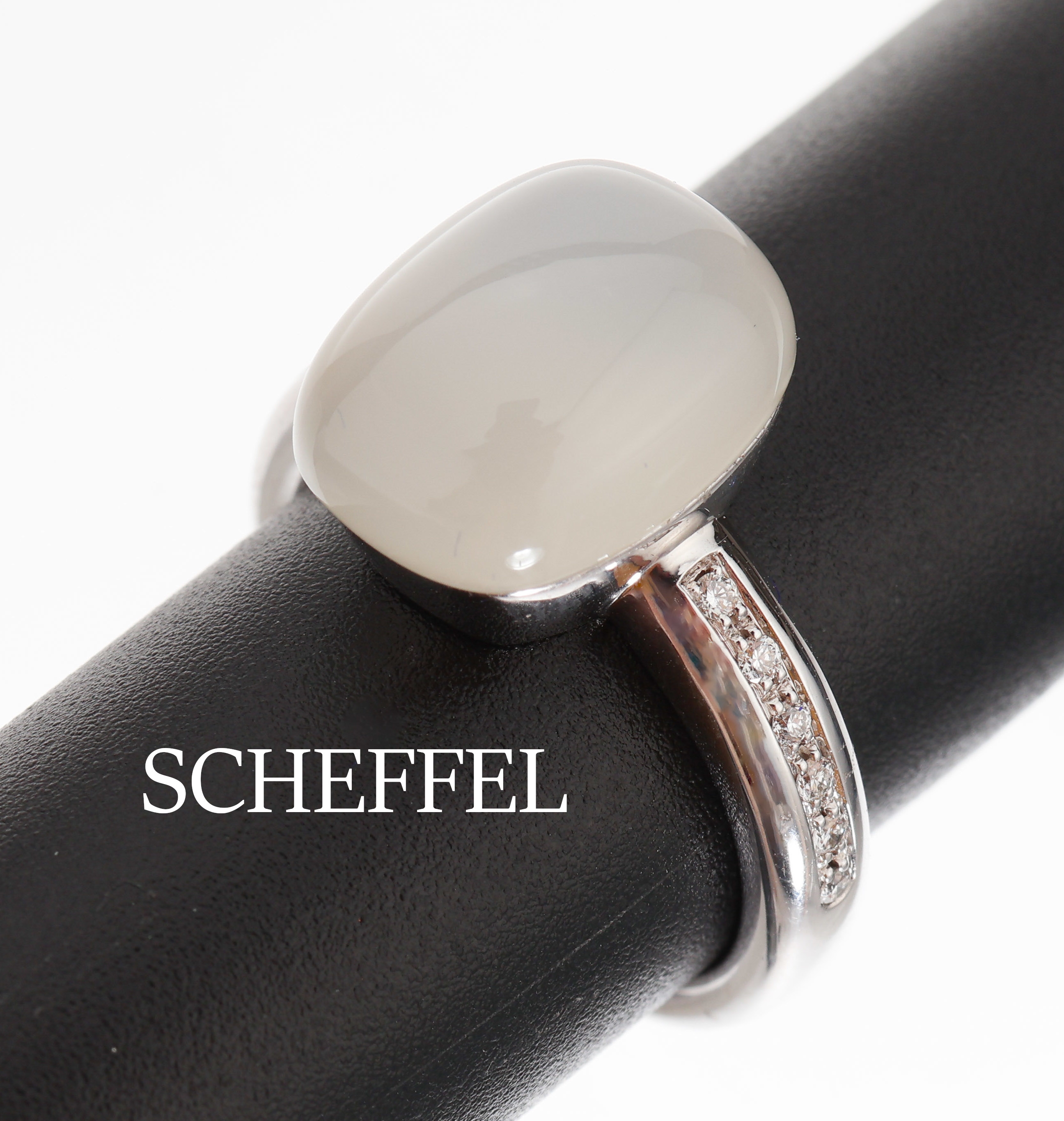 18 kt Gold SCHEFFEL Mondstein-Brillant-Ring, WG 750/000, kissenf. Mondsteincabochon ca. 7.56 ct, 12 Brillanten zus. ca. 0.10 ct feinesWeiß/vs, RW ...