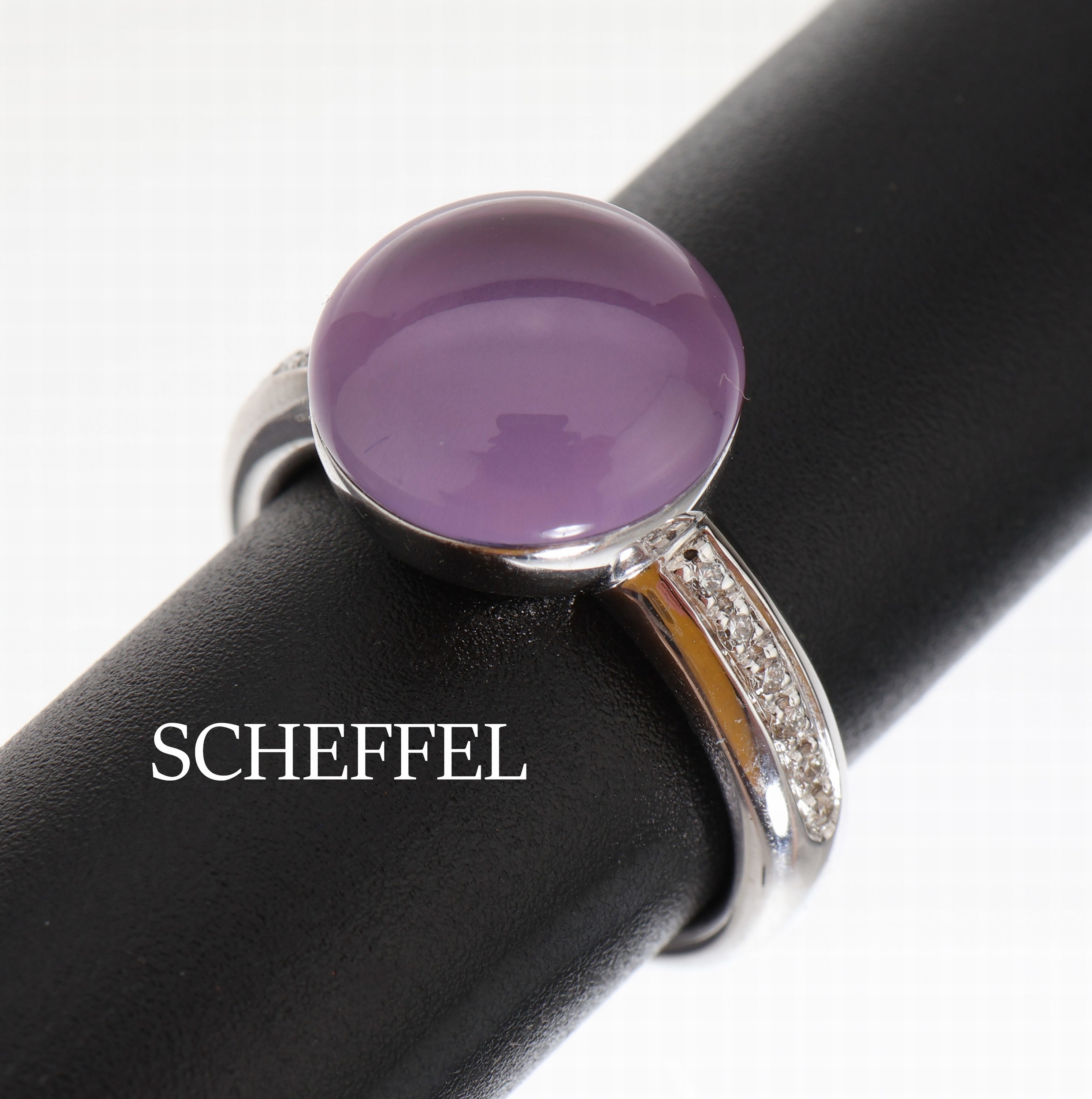 18 kt Gold SCHEFFEL Amethyst-Brillant-Ring, WG 750/000, runder Amethyst-Cabochon ca. 6.19 ct, 12 Brillanten zus. ca. 0.10 ct feines Weiß/vs, RW 56
