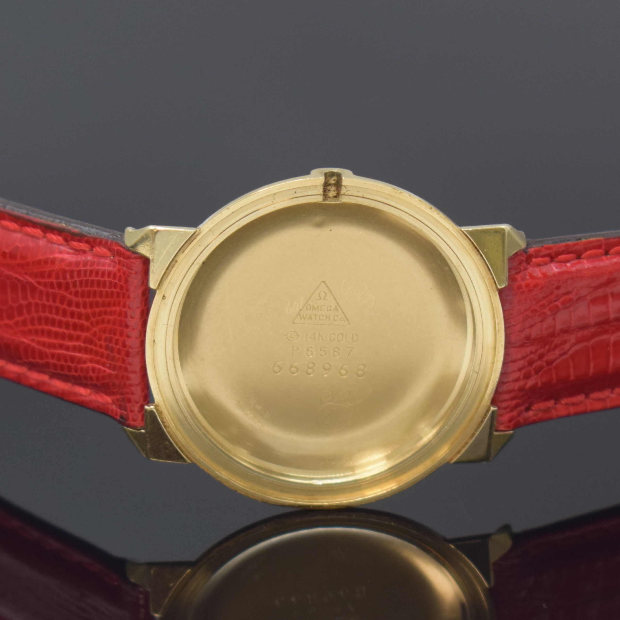 Detail d: OMEGA Herrenarmbanduhr in GG 585/000 Referenz P6587, Handaufzug, Schweiz / USA um 1966, Monocogue-Geh., Glasrand aufgedr., Boden m. Widmungsgravur, ...