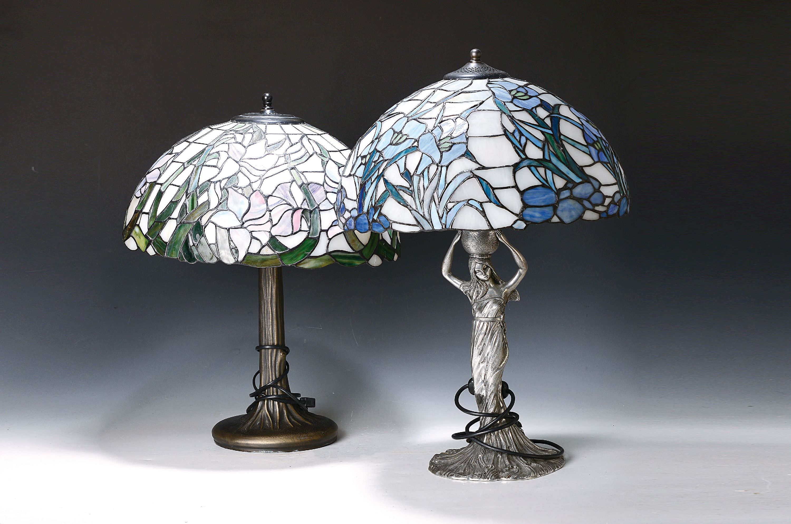 2 Tischlampen mit Tiffanystil-Schirmen, Italien, 20.Jh., 1x Metallfuß in organischer Form, 1x Zinnfuß in Form einer Frau mit Korb bez. FUSCO, H. 55 ...