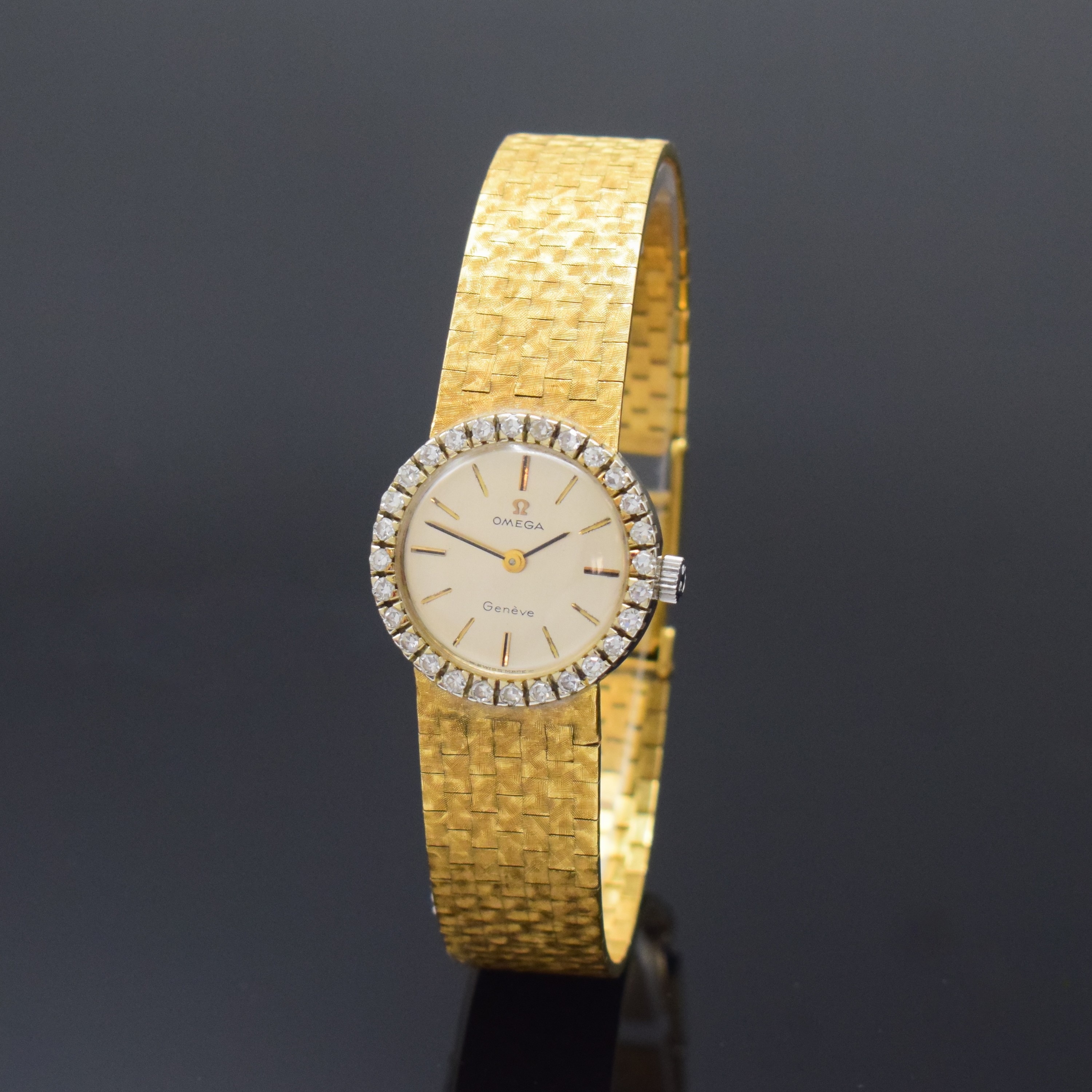 OMEGA Diamant-besetze Damenarmbanduhr in GG 750/000, Schweiz um 1970, Handaufzug, NEUTRALES Geh. u. Band, Boden aufgedr., silb. Zifferbl., gold. ...