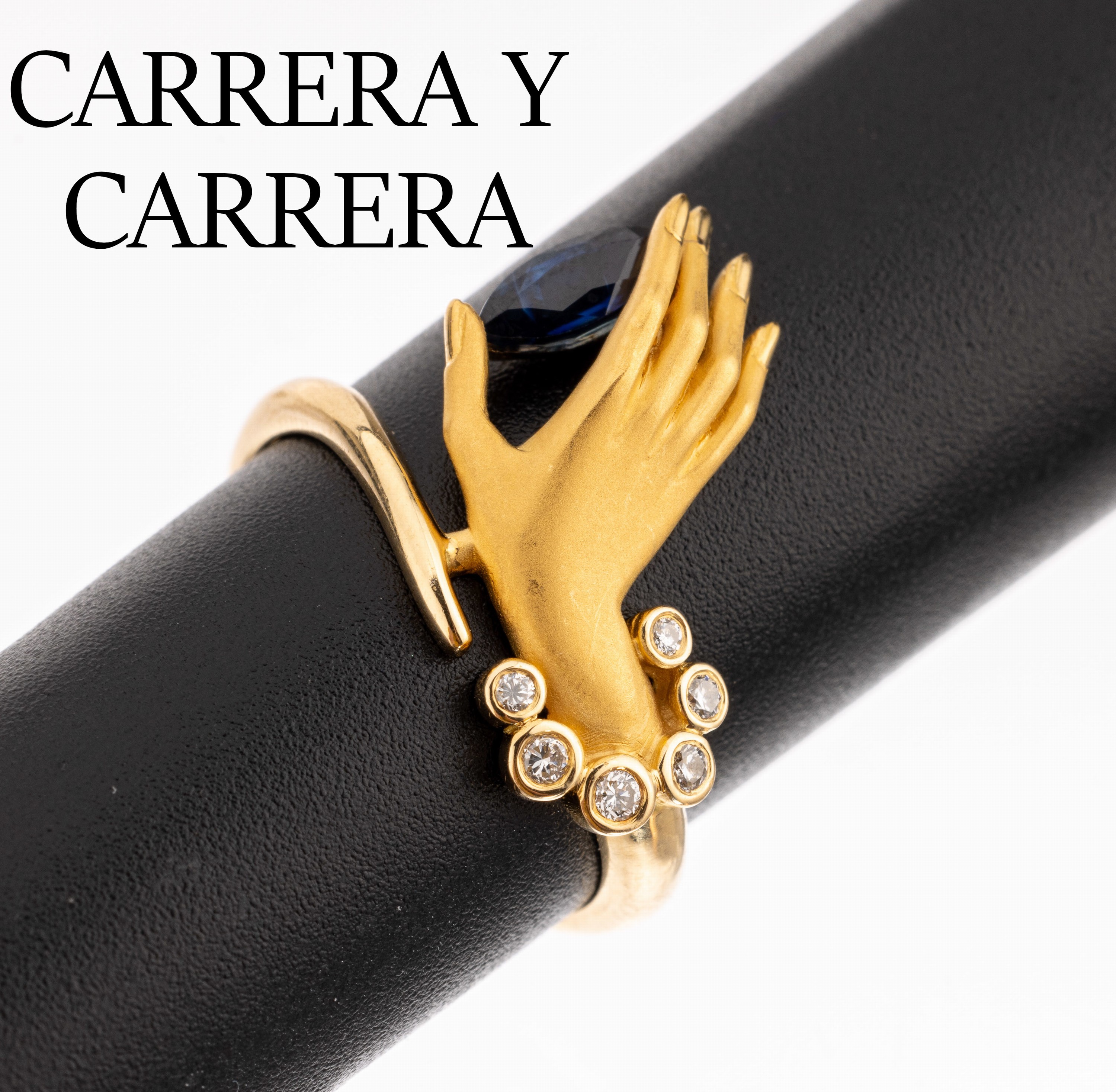 18 kt Gold CARRERA Y CARRERA Saphir-Brillant- Ring, GG 750/000, vollplastische Hand (sat.), 1 Saphir-Navette ca. 0.20 ct, 6 Brillanten zus. ca. 0.05 ...