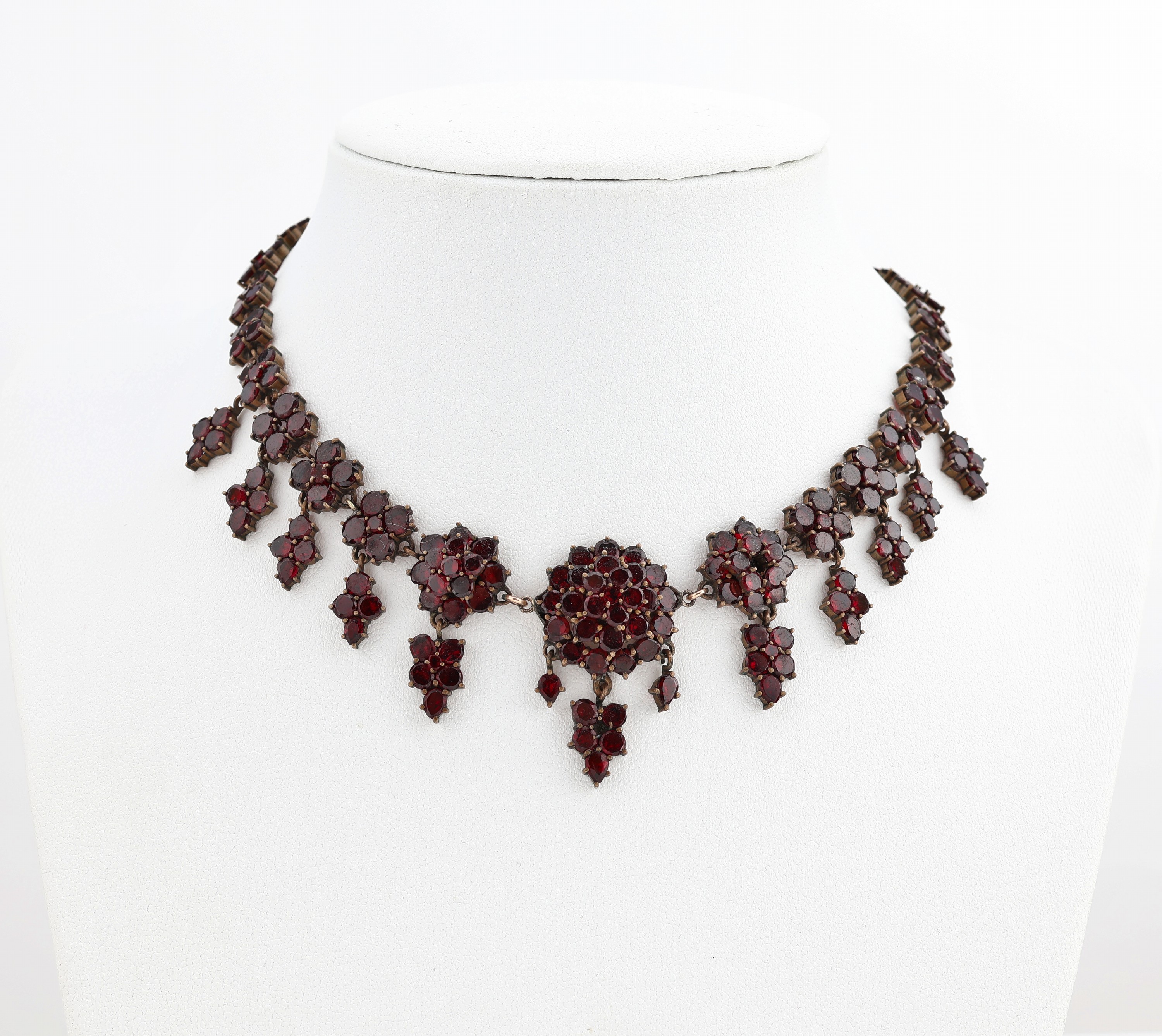 Granat-Collier, um 1880, Tombak, Spiegelgranate, teilw. mit bewegl. Abhängungen, L. ca. 42.5 cm, Kastenschloss mitSicherheitskettchen
