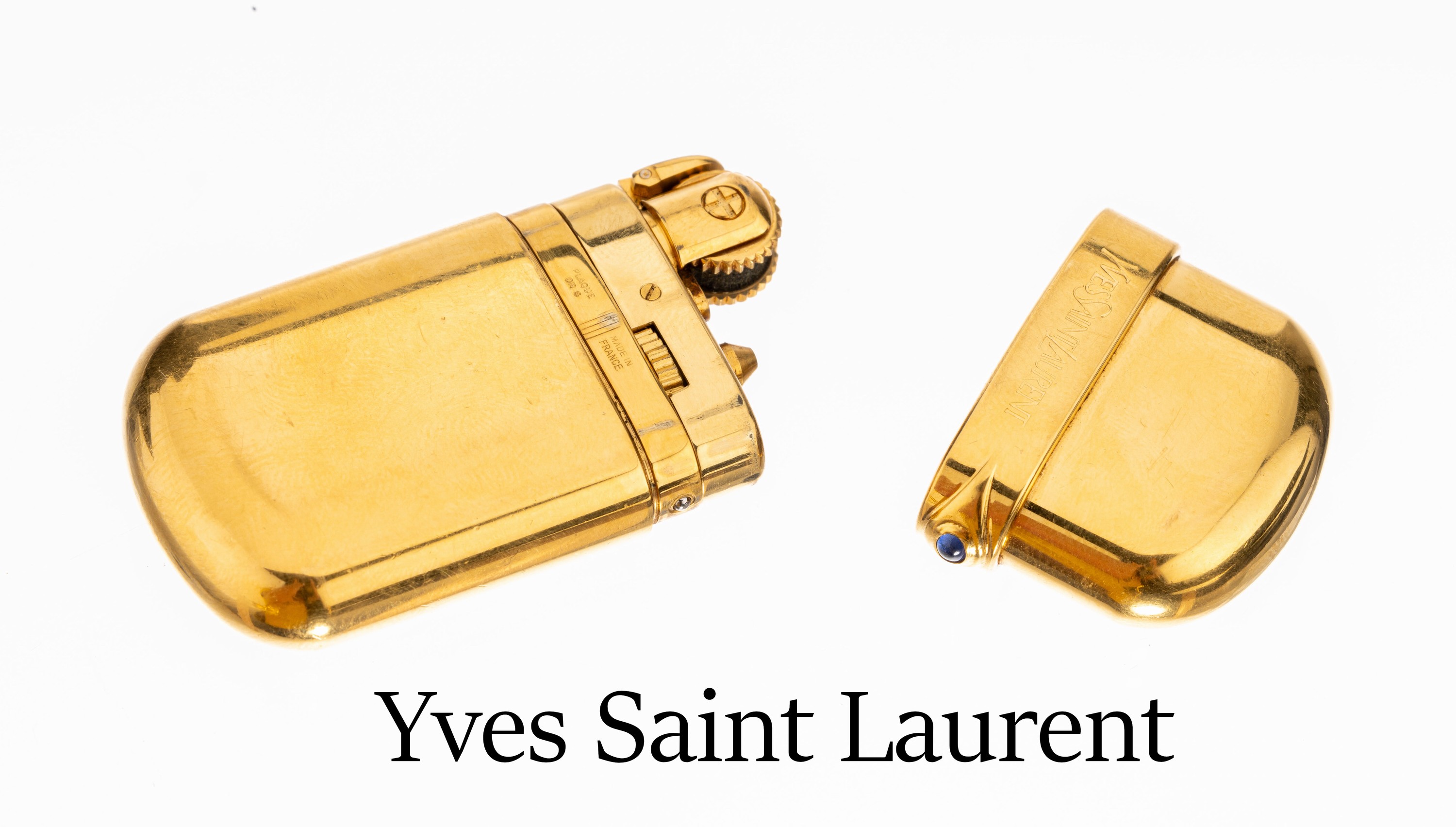 Yves Saint Laurent Feuerzeug, Metall verg.,Deckel abnehmbar mit kl. Saphircabochon, Fkt. ungeprüft, sign. und num.