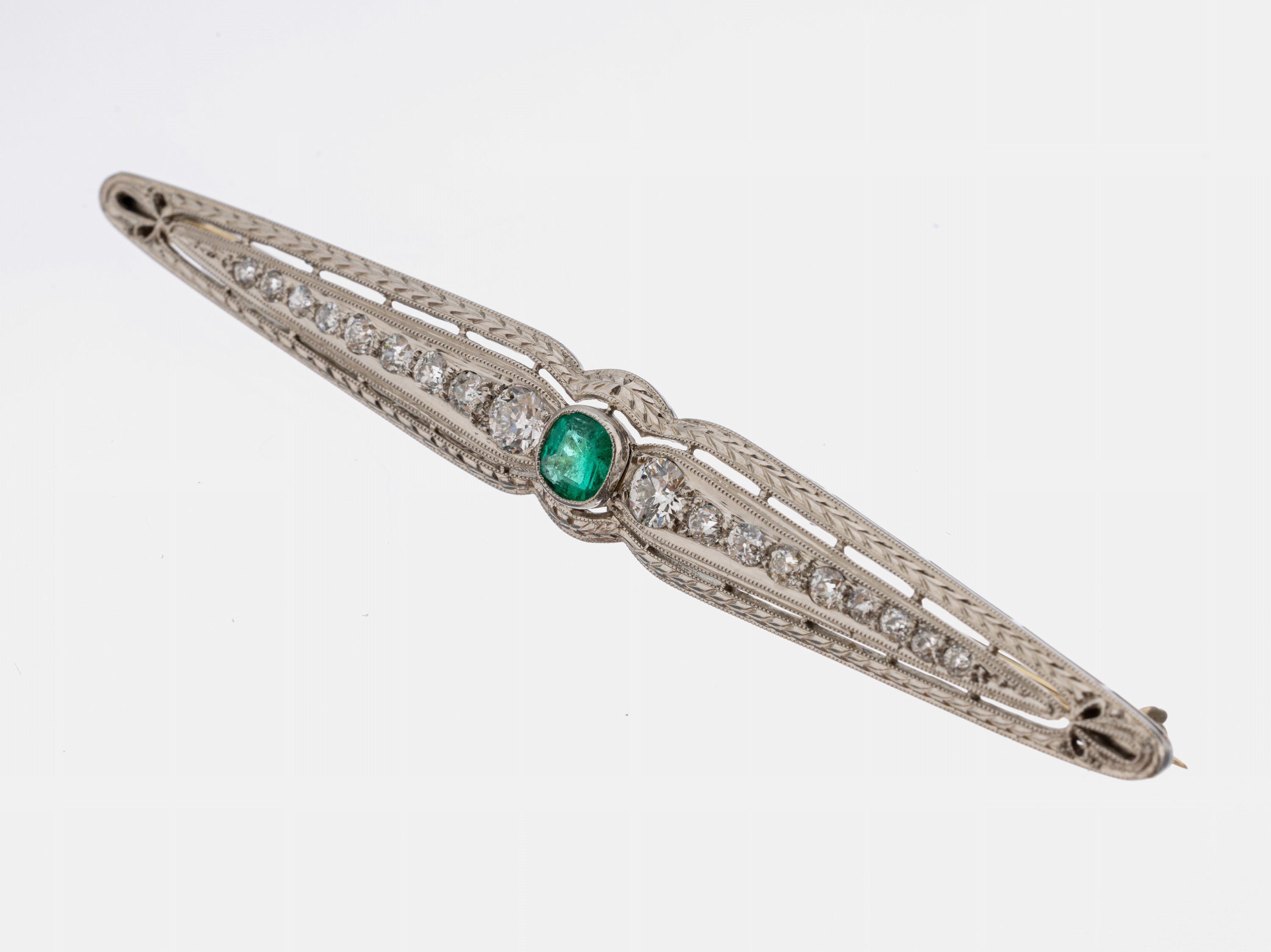 Art Deco Platin Smaragd-Diamant-Brosche, um 1920, Pt gepr., längliche angedeutete Schleifenform, durchbrochen gearbeitet, florales umlaufendes ...