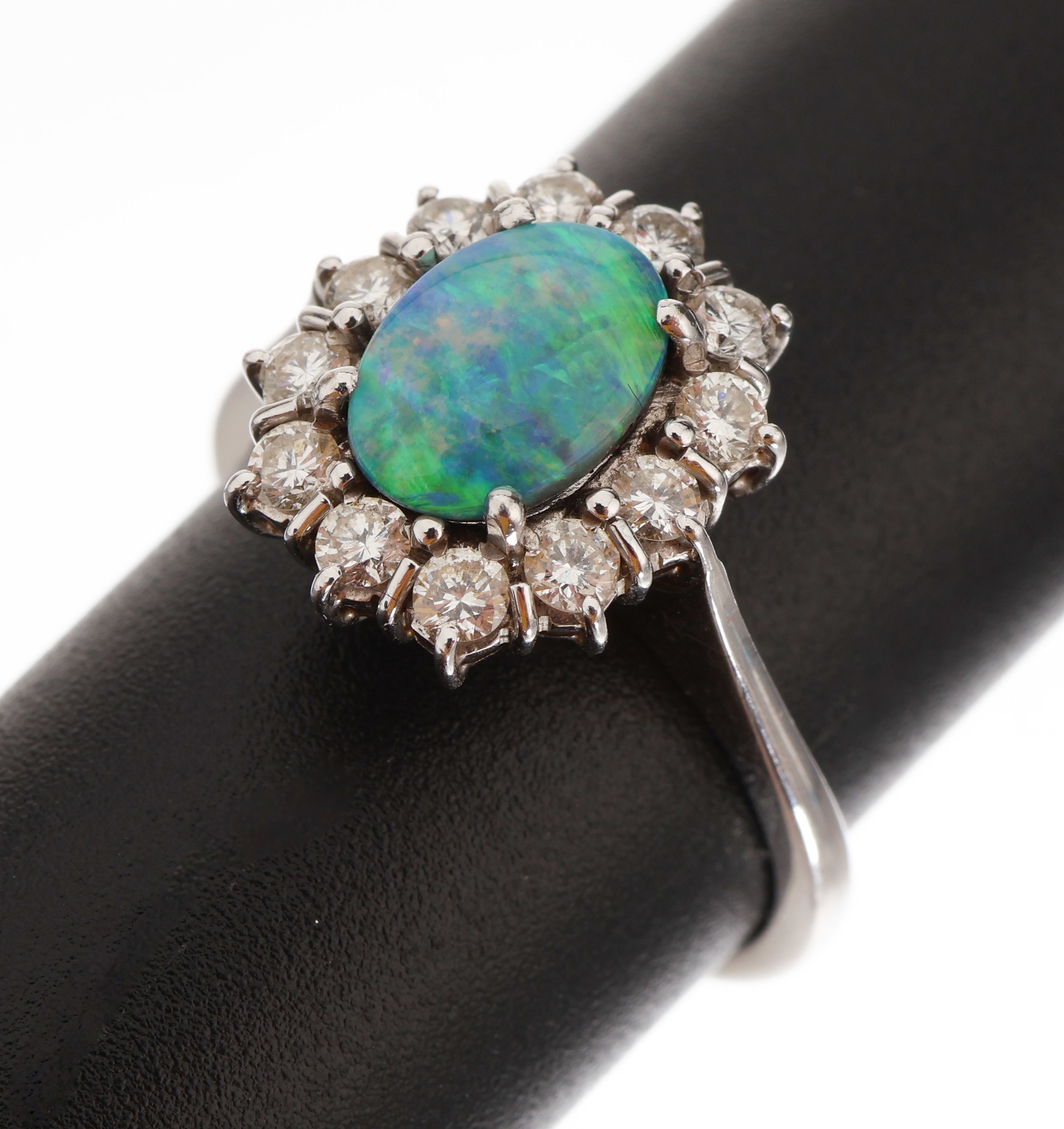 18 kt Gold Opal-Brillant-Ring, WG 750/000, mittig ovaler Schwarzopal ca. 0.80 ct, Farbspiel in blau und grün, umgeben von 12 Brillanten zus. ca. ...