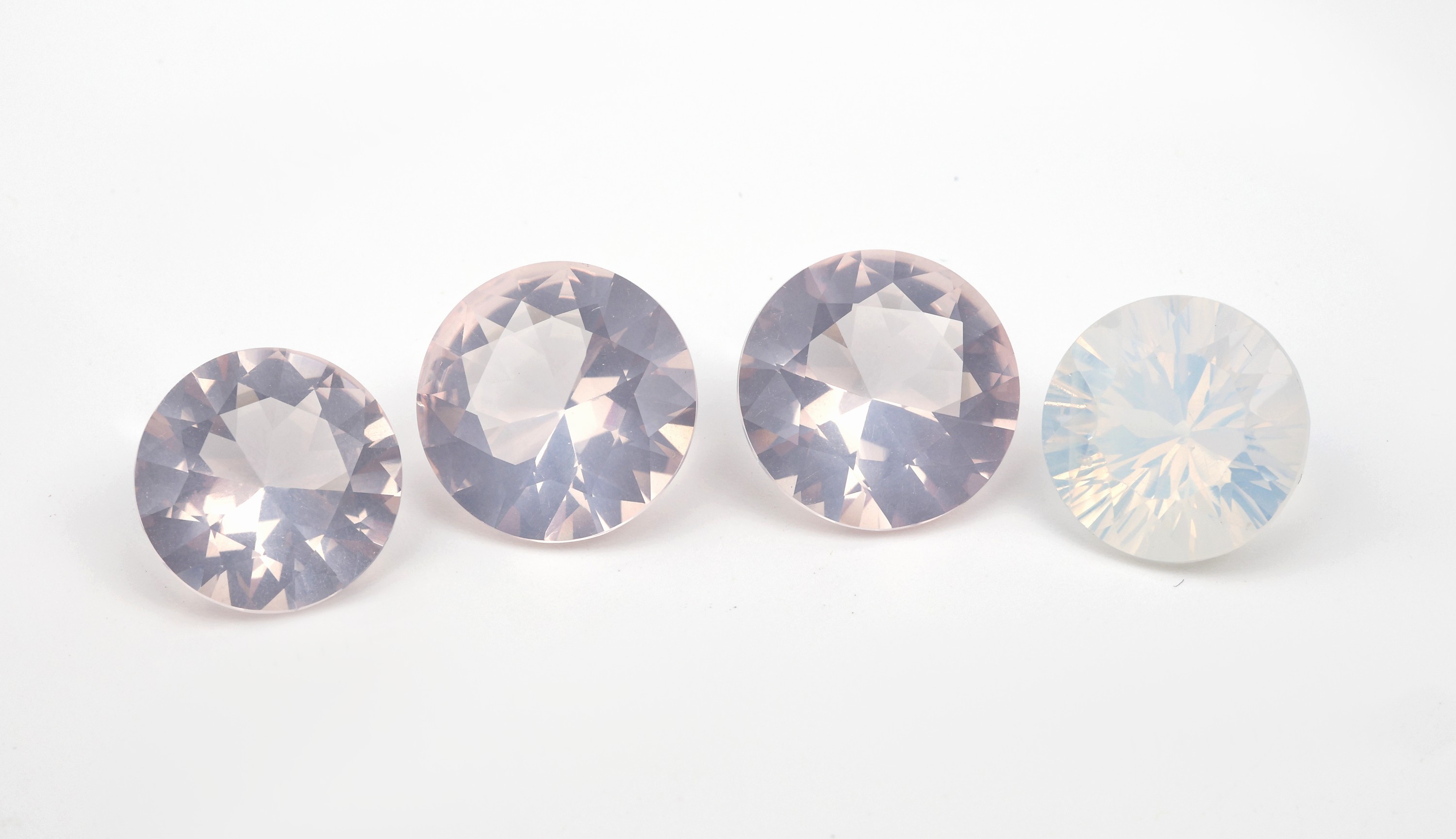 Lot 4 lose facett. Milchquarze, zus. 40.69 ct, rund, 3 x l. rose, 1 x weiss