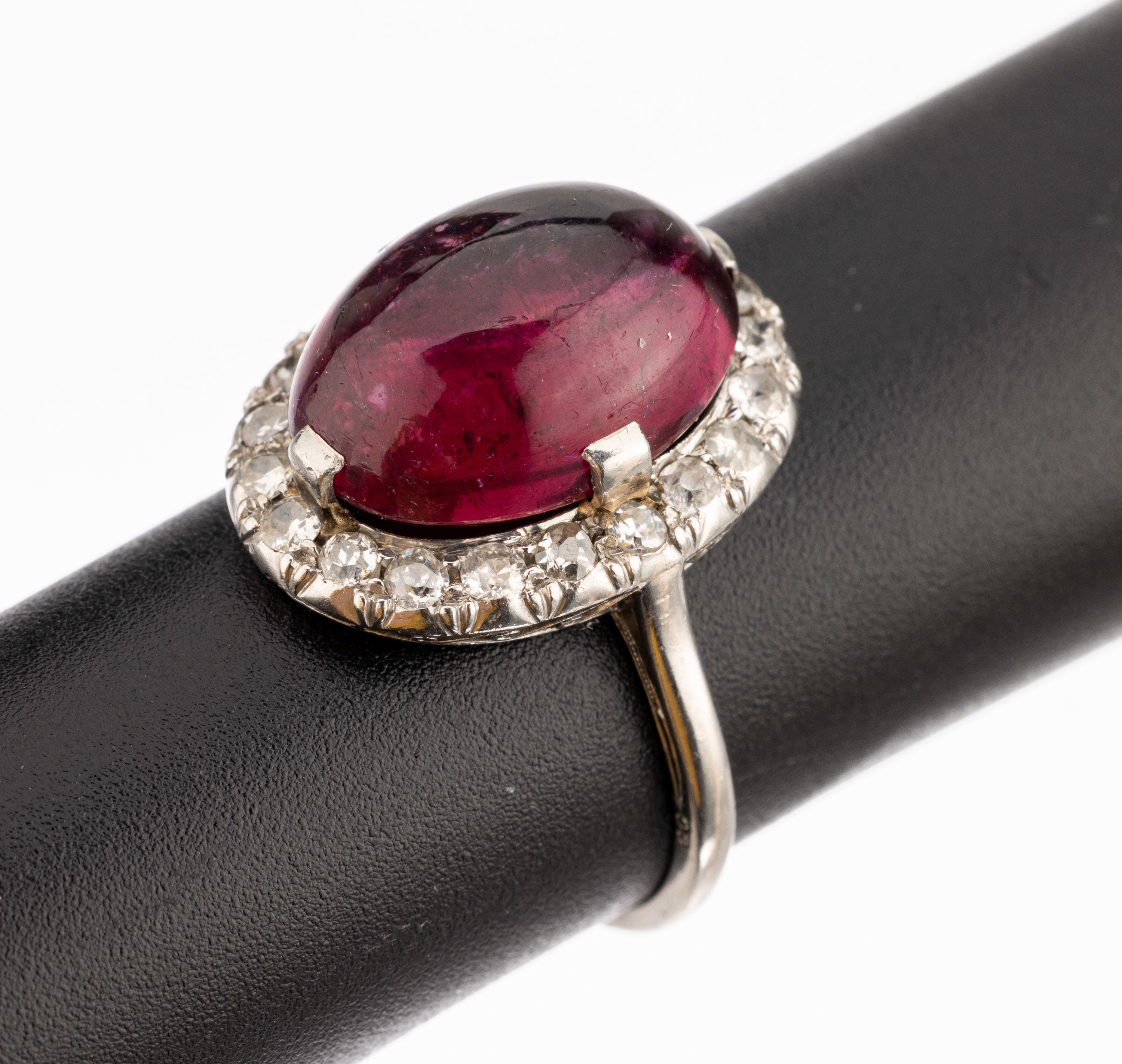 14 kt Gold Rubellit-Diamant-Ring, um 1925-30, WG 585/000 gepr., mittig ovaler Rubellit- Cabochon ca. 5.0 ct, umgeben von 20 Brillanten, ...