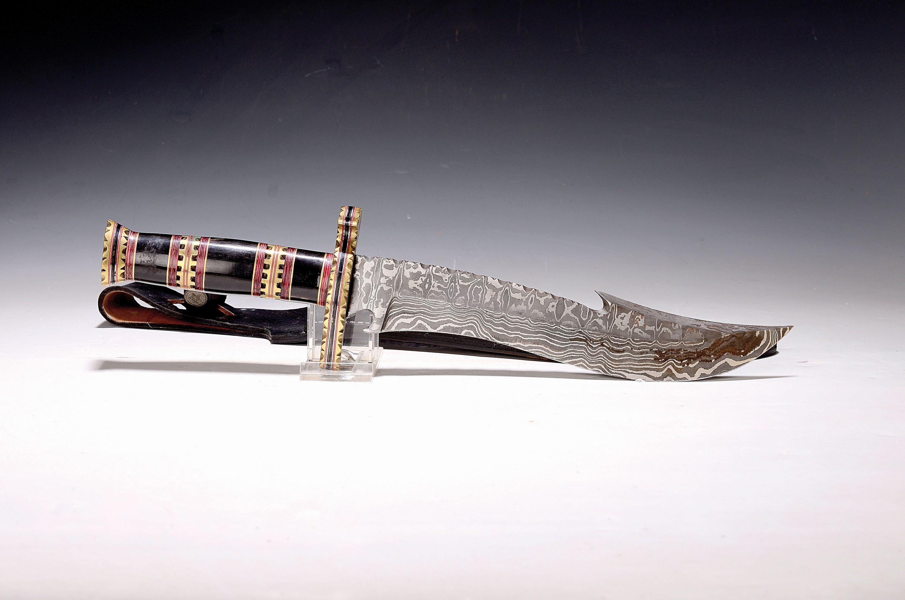 Jagdmesser/Dolch, wohl Kanada, 20. Jh., Damaststahlklinge, Griff mit Messing und Horn, Lederscheide, L. ca. 39 cm
