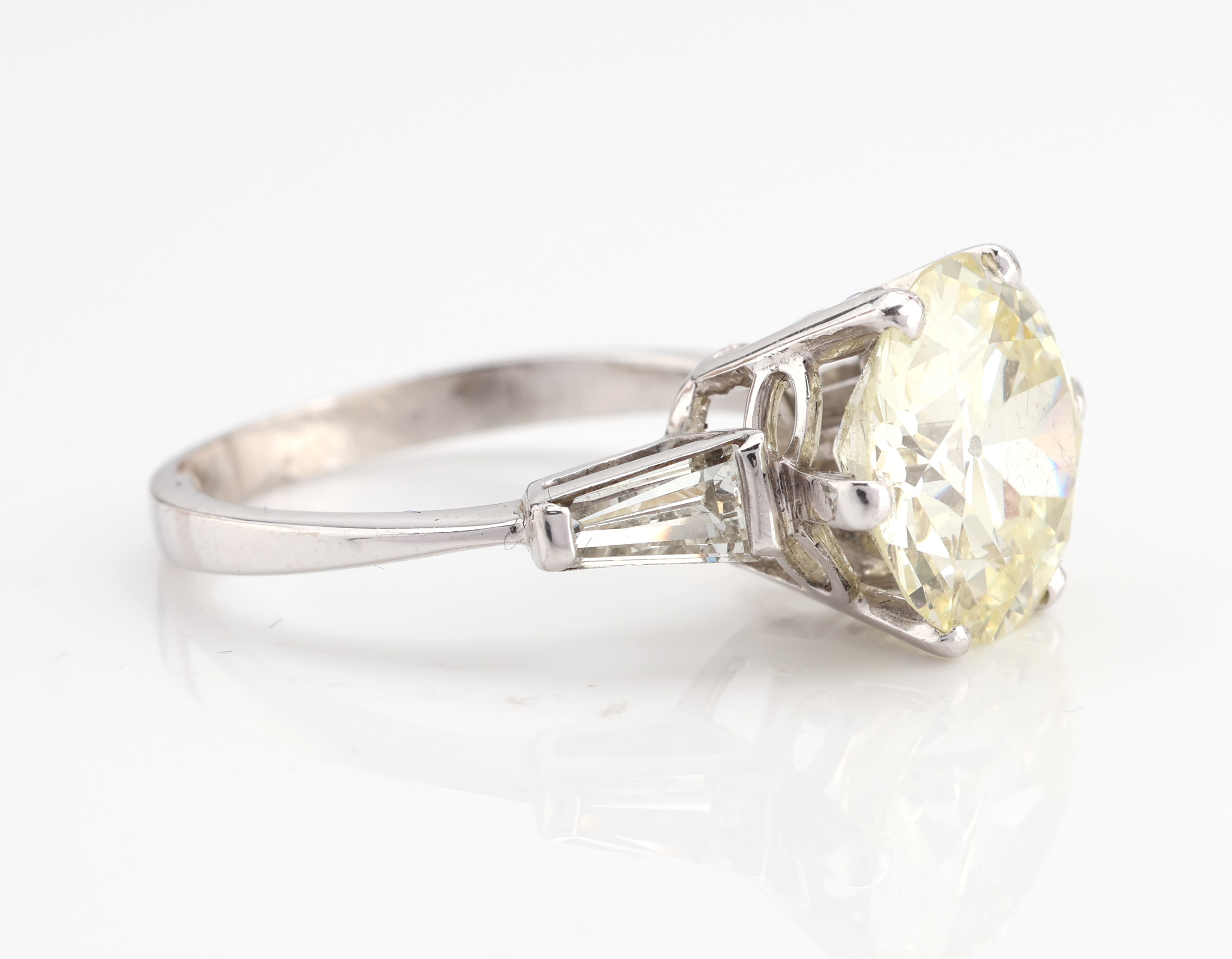 Detail c: 14 kt Gold Diamant-Ring, WG 585/000, mittigAltschliffdiamant ca. 4.50 ct Getönt/si, (Stein min. besch.), seitl. 2 Diamanttrapeze zus. ca. 0.30 ct ...