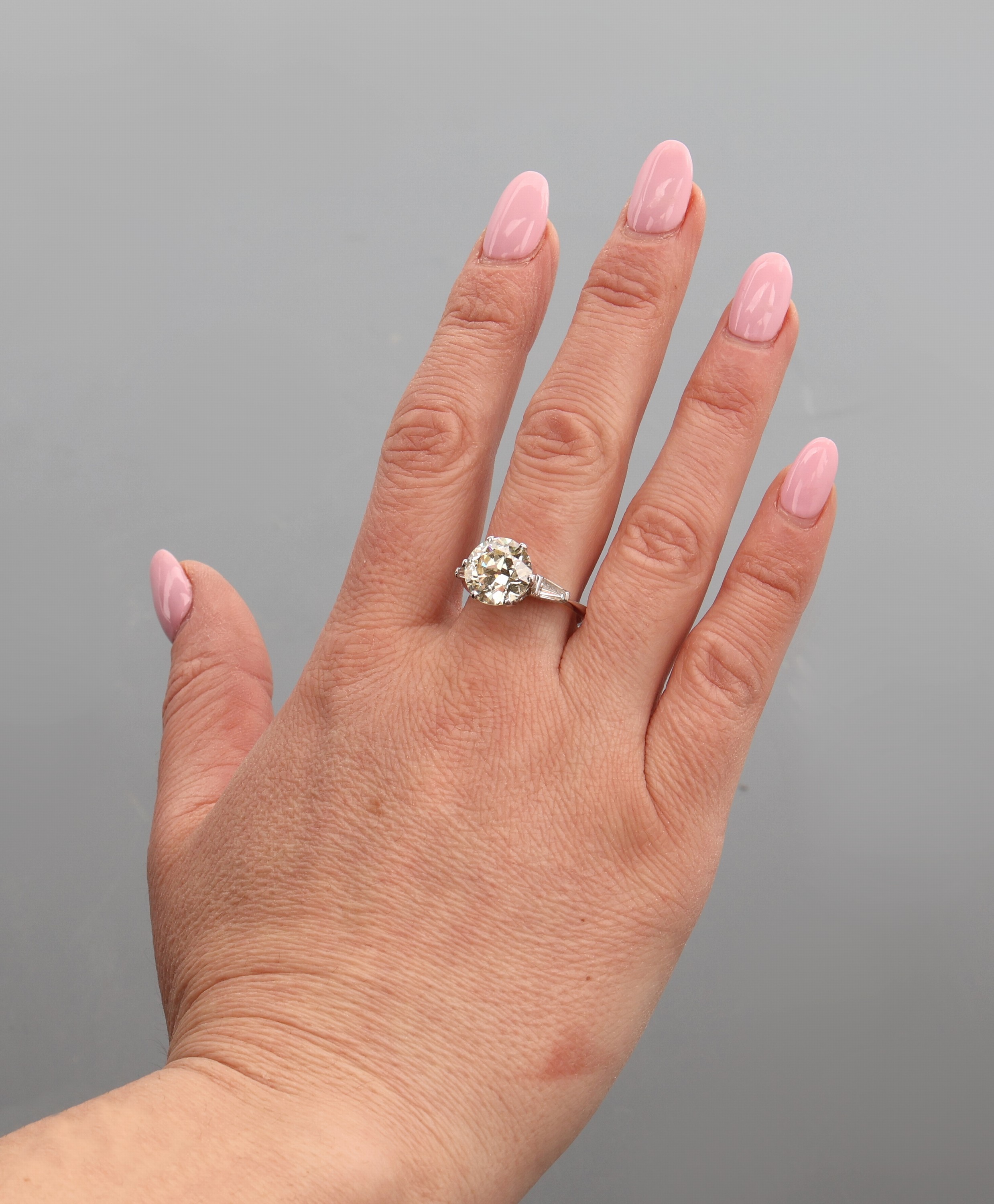 Detail d: 14 kt Gold Diamant-Ring, WG 585/000, mittigAltschliffdiamant ca. 4.50 ct Getönt/si, (Stein min. besch.), seitl. 2 Diamanttrapeze zus. ca. 0.30 ct ...
