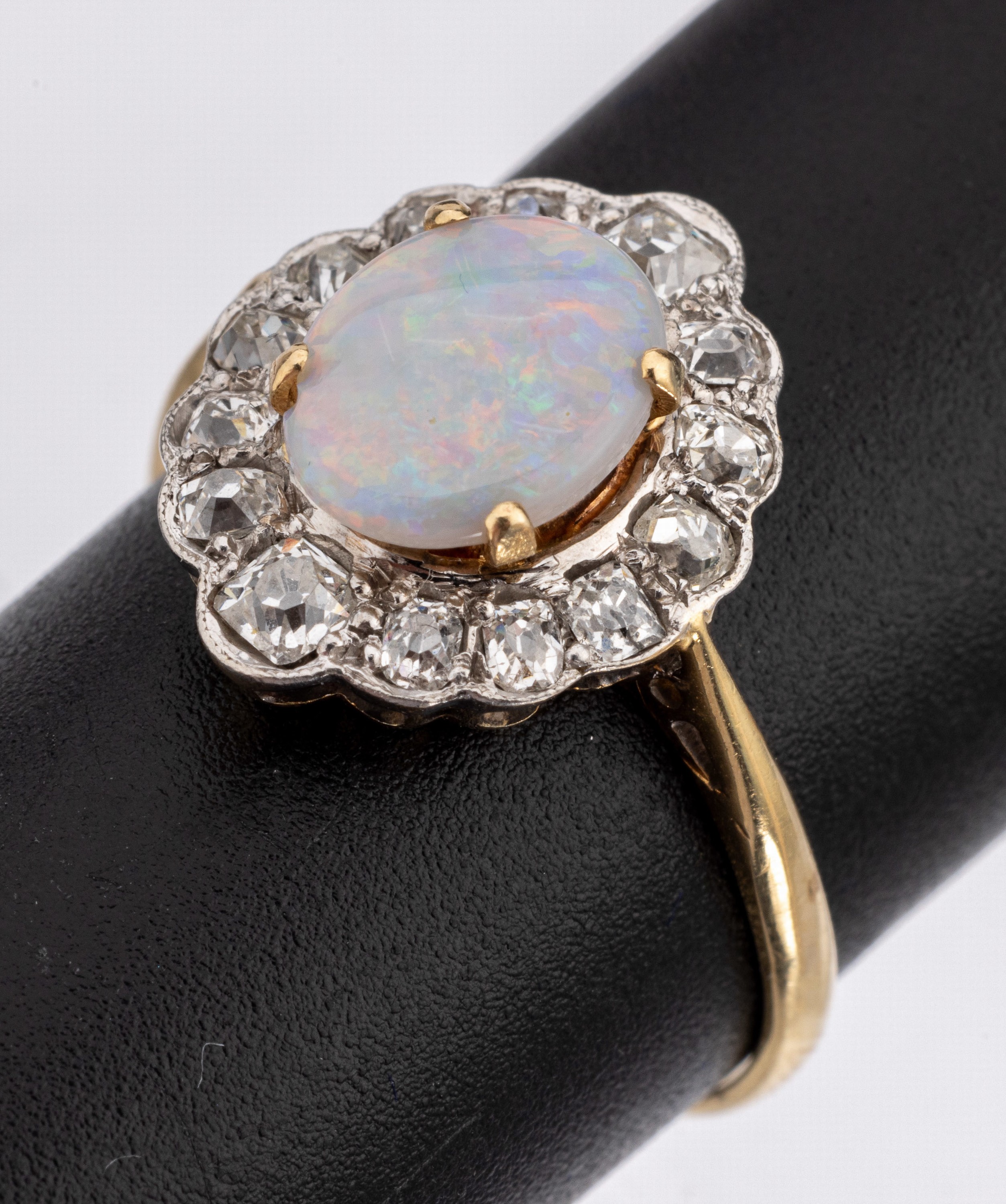 18 kt Gold Opal-Diamant-Ring, GG 750/000 und Platin, um 1910, ovaler Opal ca. 0.60 ct, 14 Altschliff-Diamanten zus. ca. 1.0 ct Weiss/si, ca. 3.4 g, ...