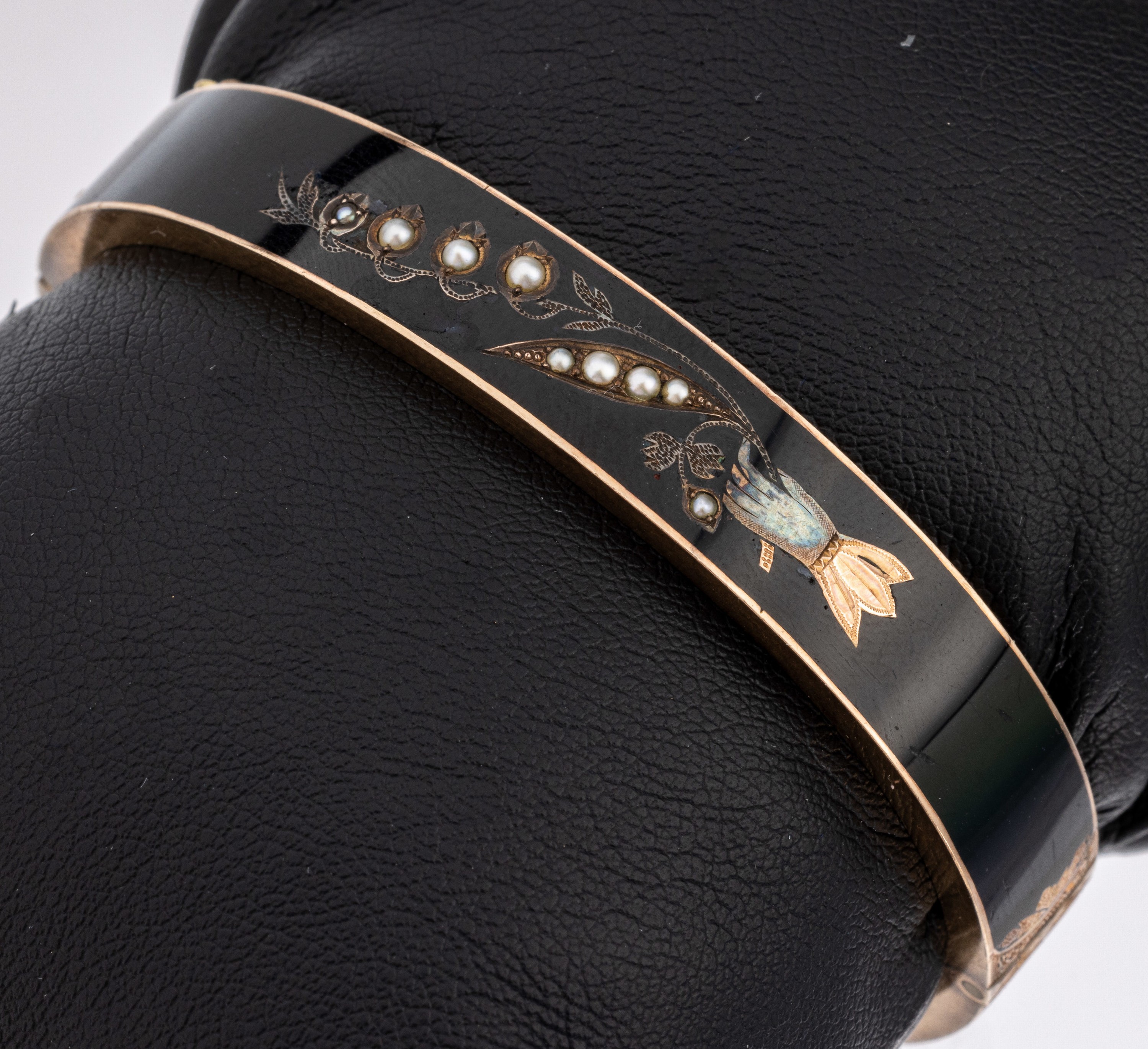 8 kt Gold Biedermeier Armreif, um 1840, RG 333/000 gepr., umlaufend schwarz emaill. (min.besch.), aufgelegtes Ornament, Hand Blütenzweig haltend, ...