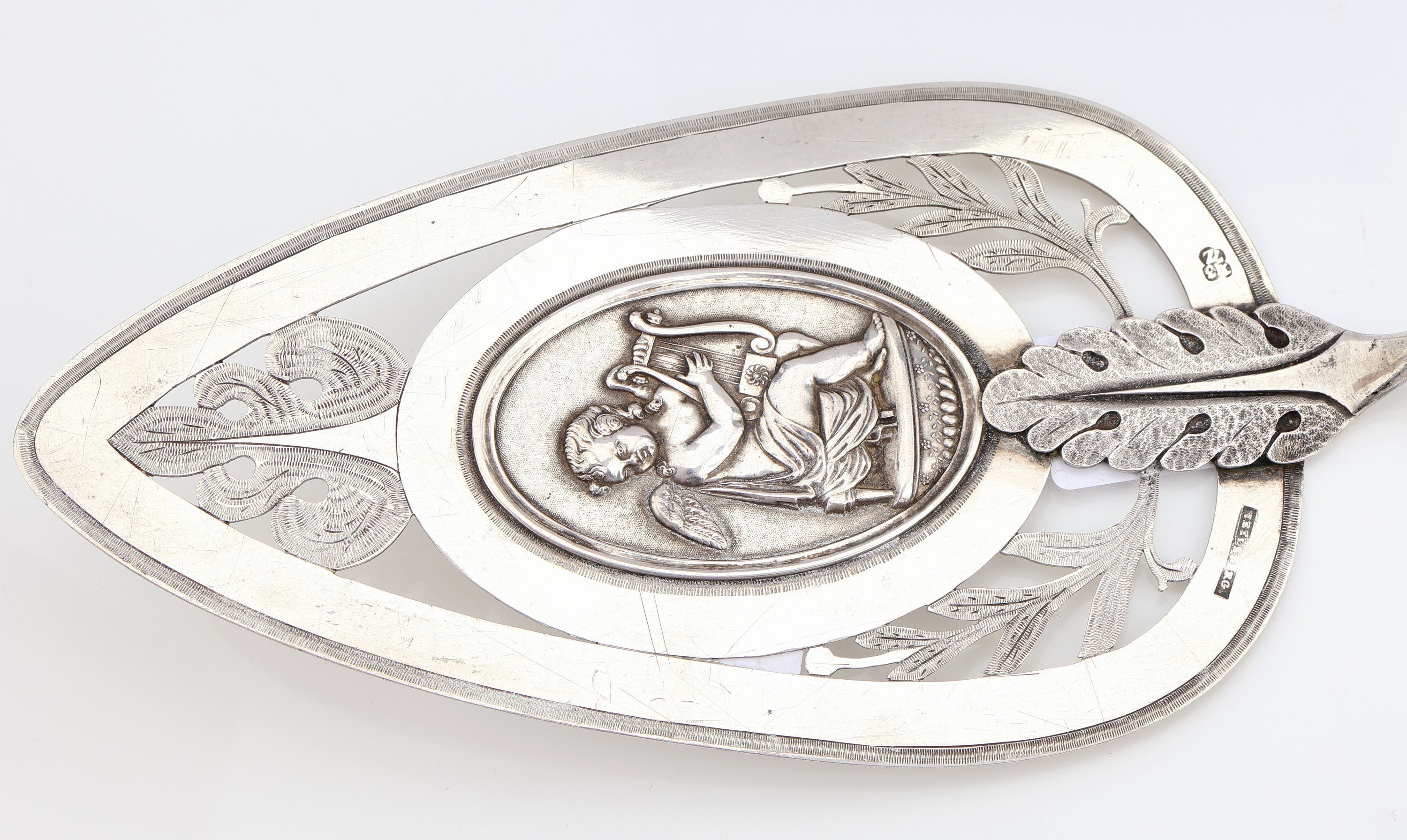 Detail e: 2 gr. Vorlegeteile, 13-Lot Silber, deutsch,1820er Jahre, 1 x tropfenf., durchbrochen, grav. und punz., mittig Darstellung eines Putto mit Harfe, ...