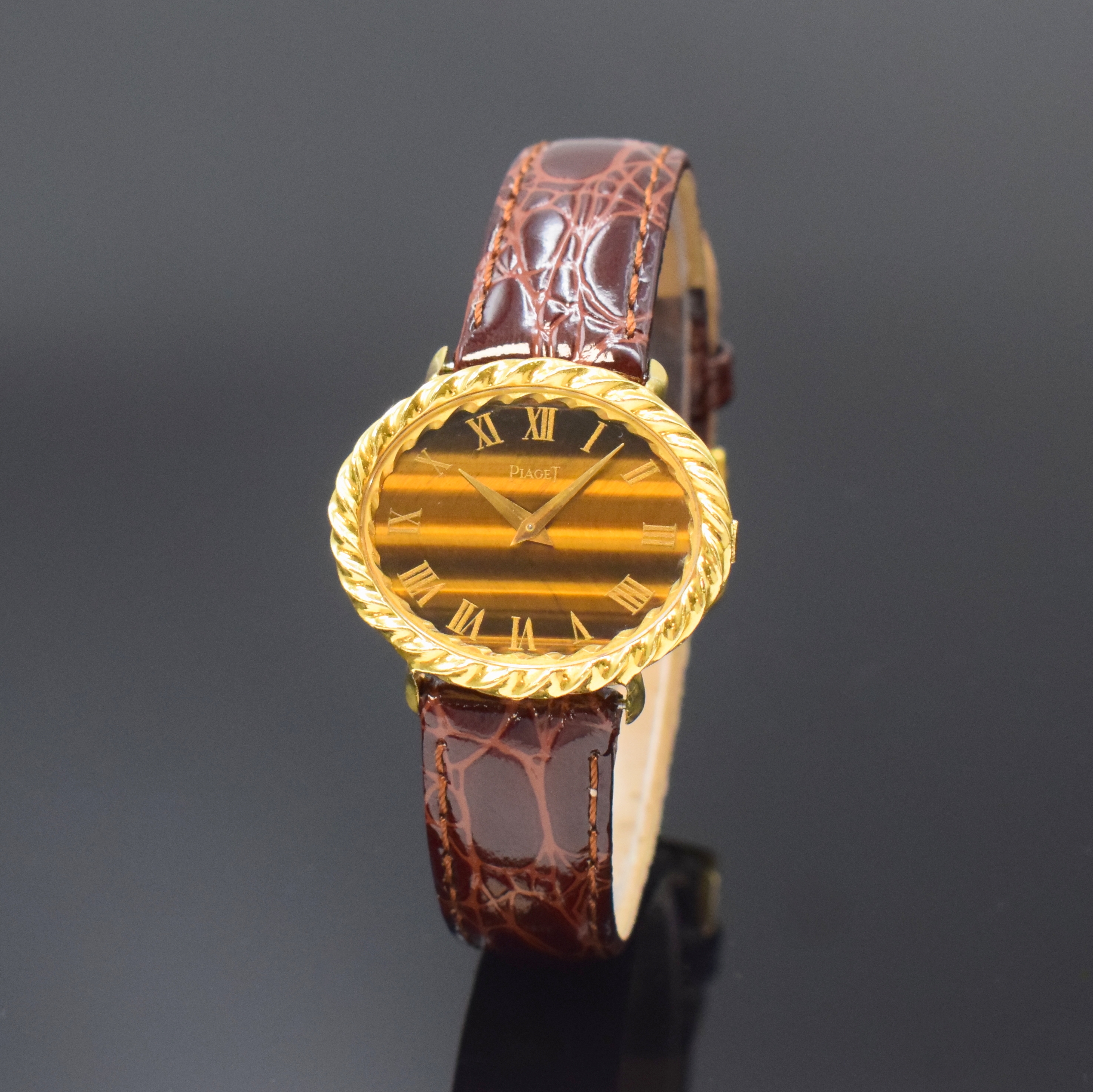 PIAGET Damenarmbanduhr in GG 750/000 Referenz 9803, Schweiz um 1960, Handaufzug, ovales Geh., Boden 2-fach verschr., Tigerauge- Zifferbl. m. röm. ...