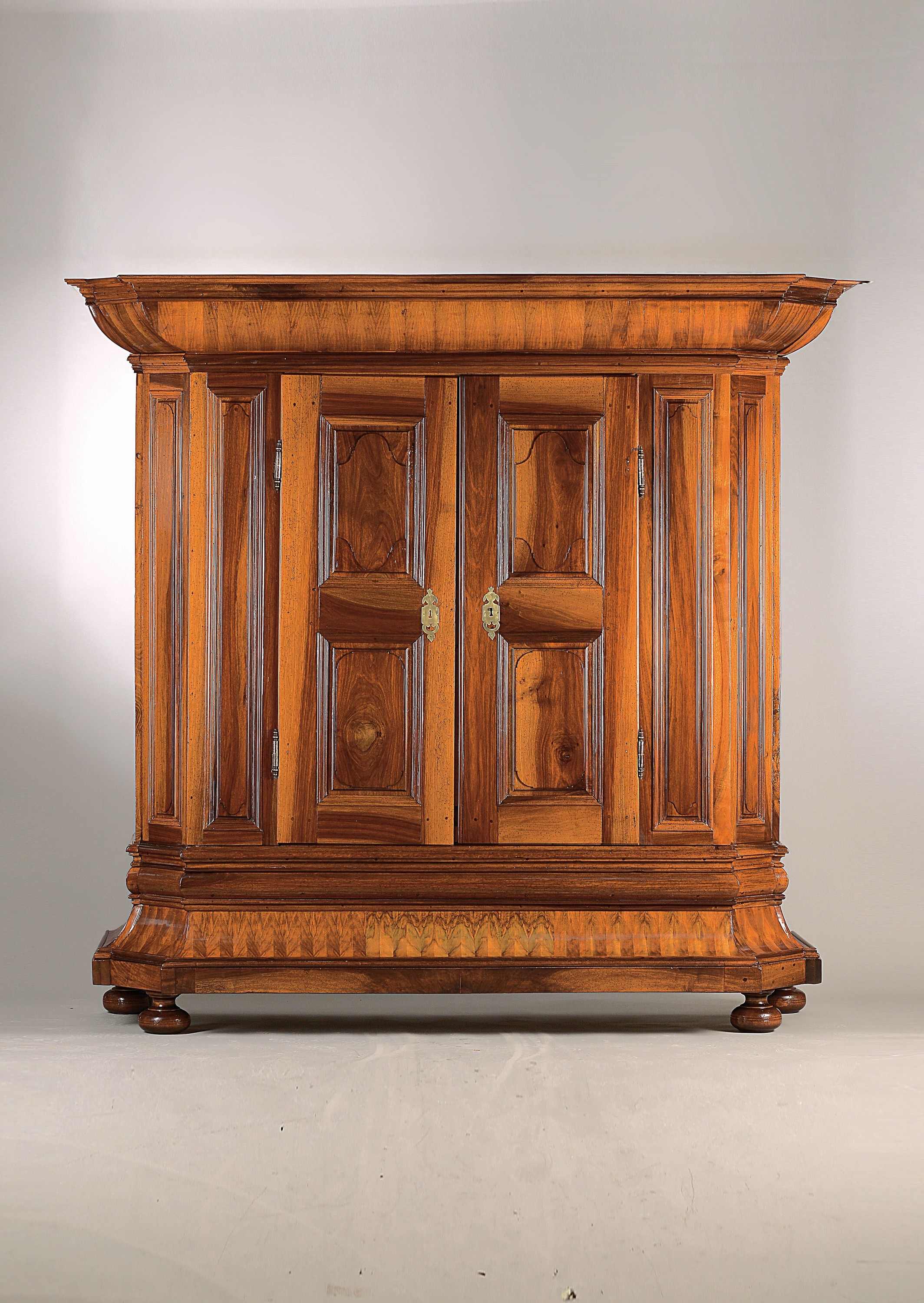 Barockschrank, wohl Bodenseeraum, 18.Jh., Nussbaum massiv, auf Rahmen gearbeitet, weit ausladender Sockel und Kopf, orig. Schloss und Schlüssel, ...
