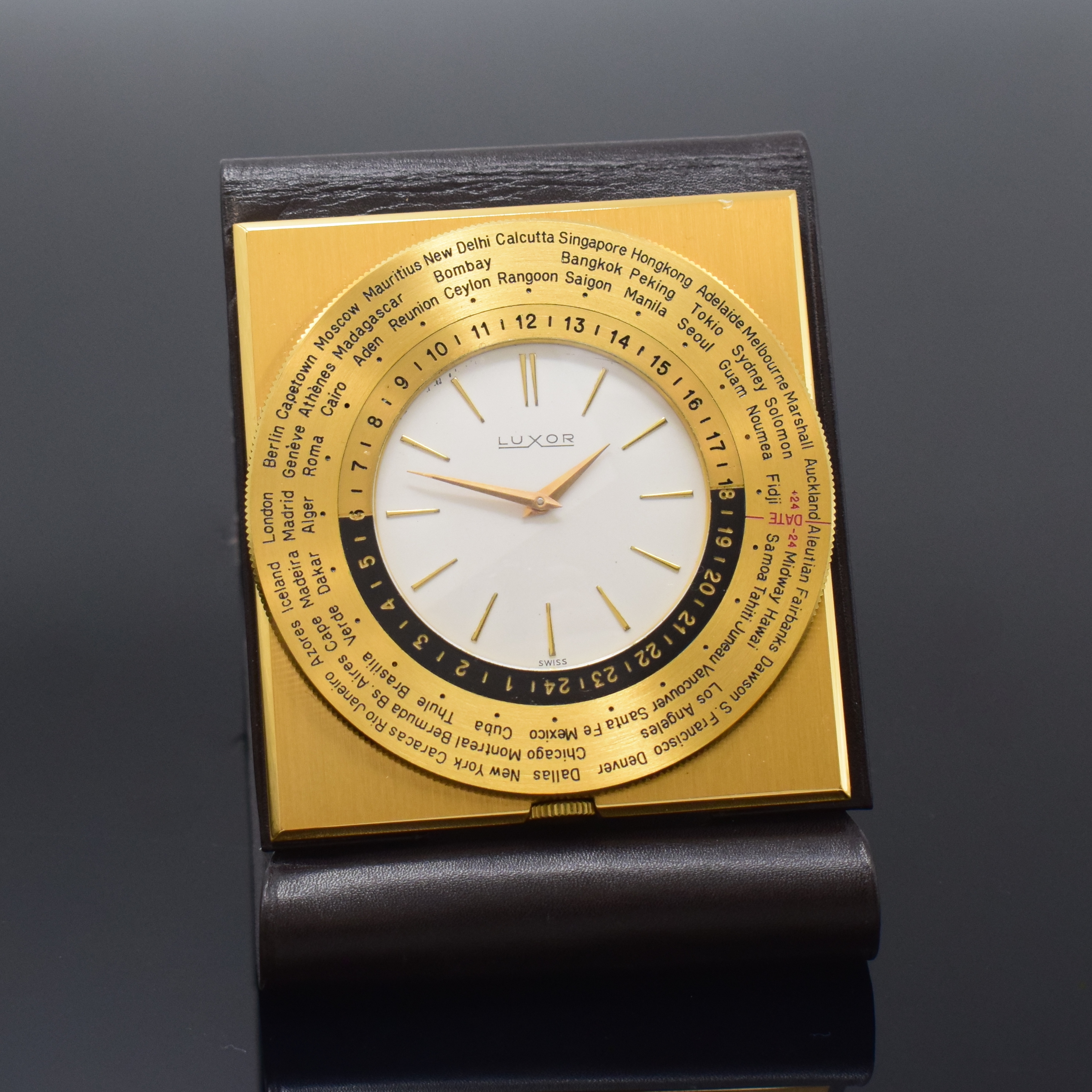 LUXOR Reiseuhr mit Weltzeitanzeige, Schweiz um 1965, Handaufzug, rechteck., verg. Geh., eingeschraubt in Lederetui, beids. drehb. Weltzeit-Lünette ...
