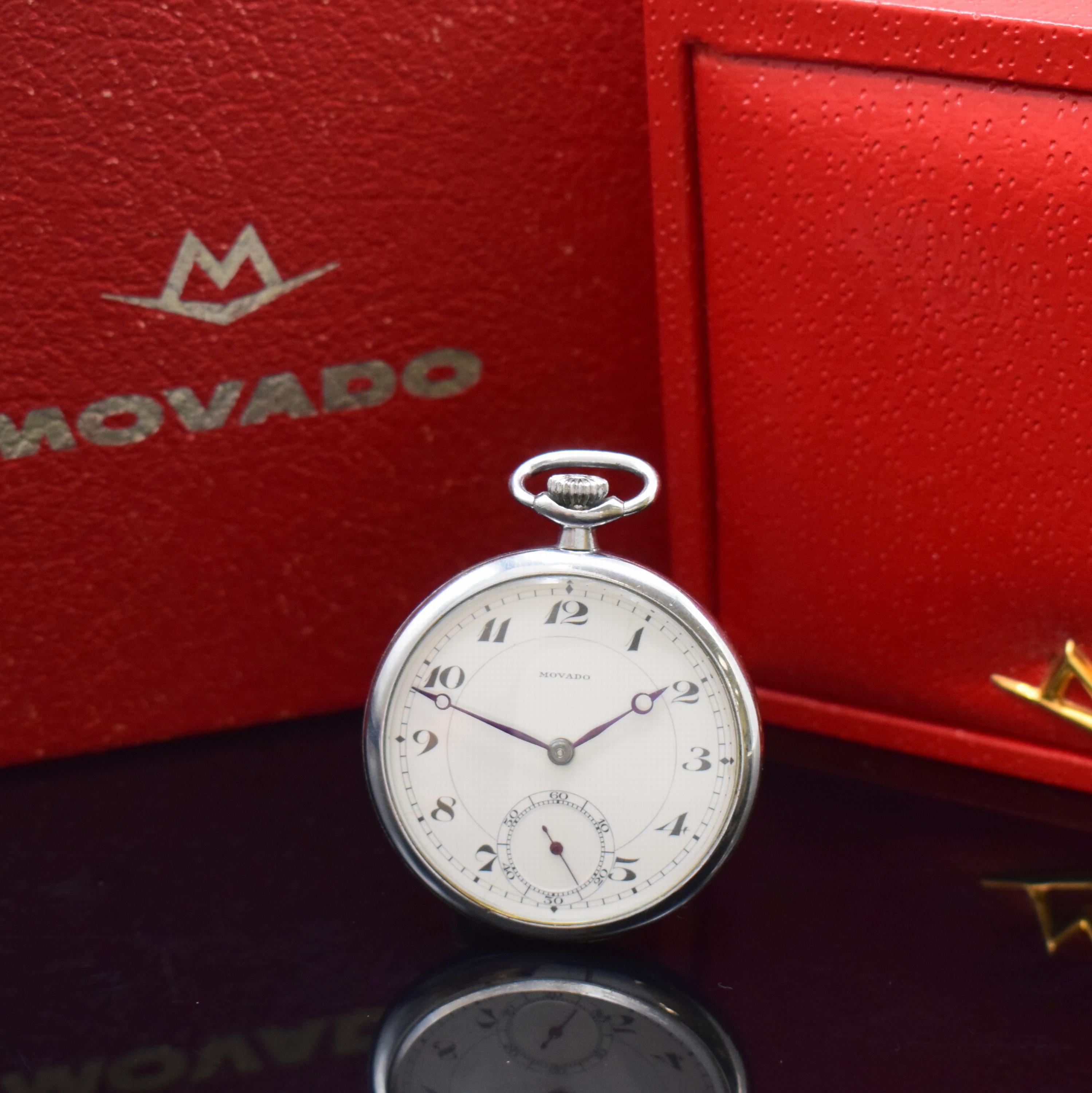 MOVADO offene verchromte Taschenuhr mit Movado Box und Umkarton, Schweiz um 1925, Handaufzug, Boden aufgedr., Emailzifferbl. riss., arab. Zahlen, ...