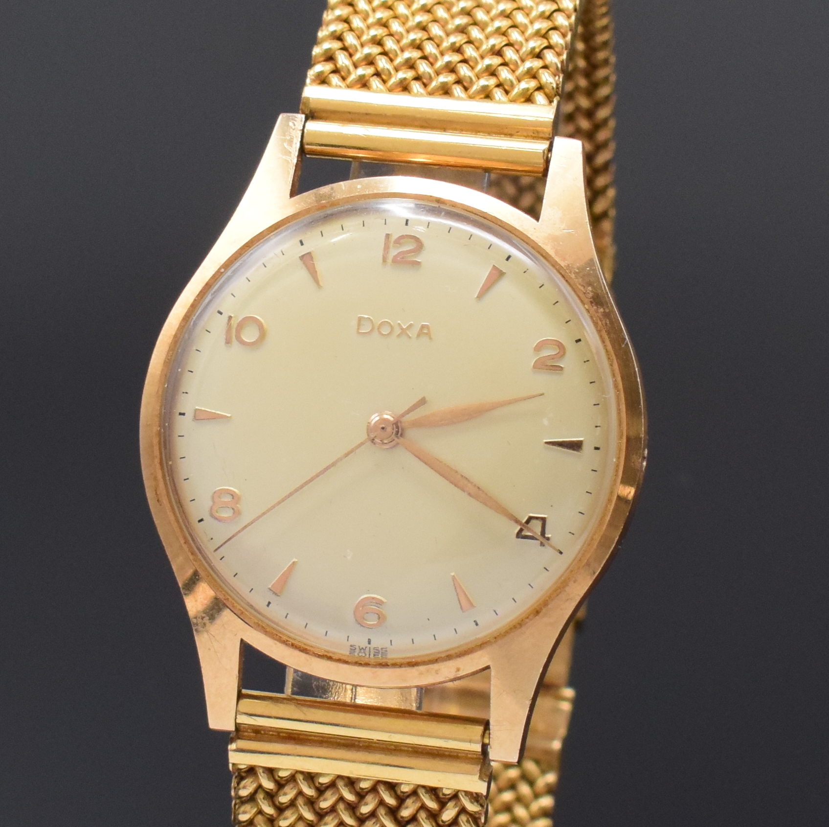 Detail a: DOXA Herrenarmbanduhr in RG 585/000, Schweiz um 1965, Handaufzug, neutr. RG 750/000 Band, Boden aufgedr., silb. Zifferbl. m. arab. Zahlen u. gold. ...