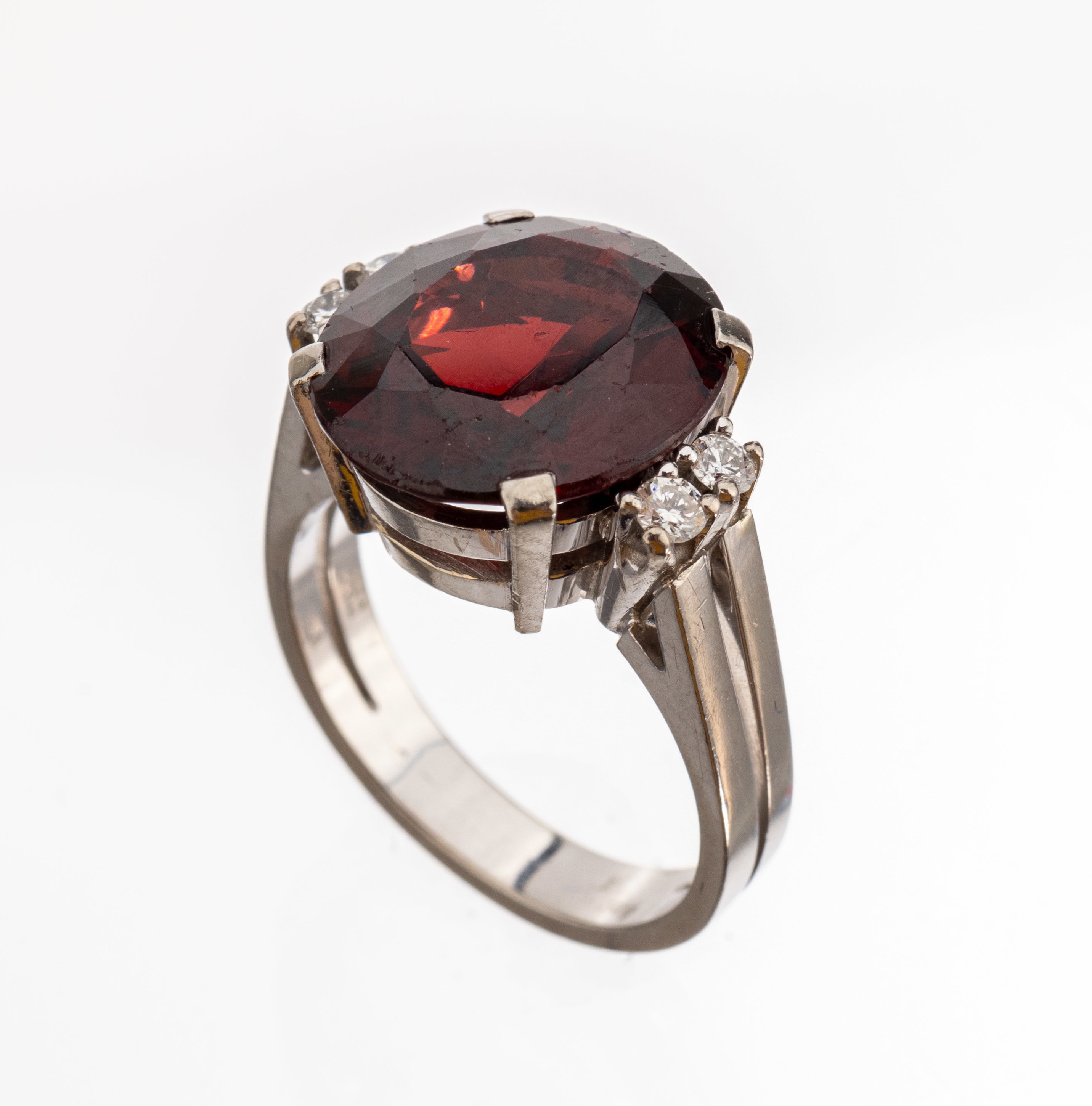 18 kt Gold Granat-Brillant-Ring, WG 750/ 000, mittig ovalfacett. Granat ca. 6.00 ct, 4 Brillanten zus. ca. 0.20 ct feines Weiß/vs, RW 54, ca. 8.8 g