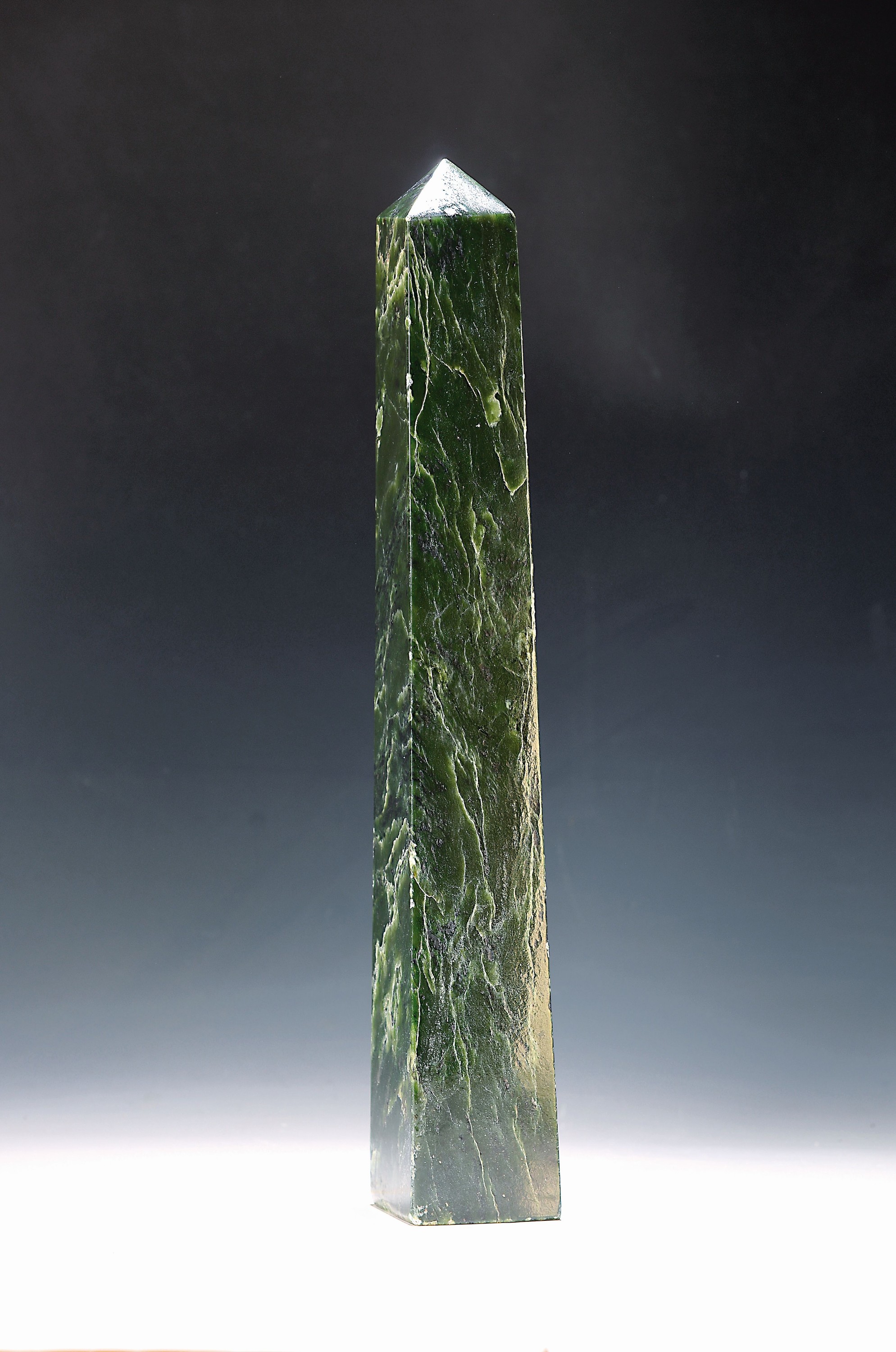 Großer Obelisk aus Nephrit, feine weiße Äderung, Kanten z.T. l. unregelmäßig, 5,7 kg, H. 50 cm