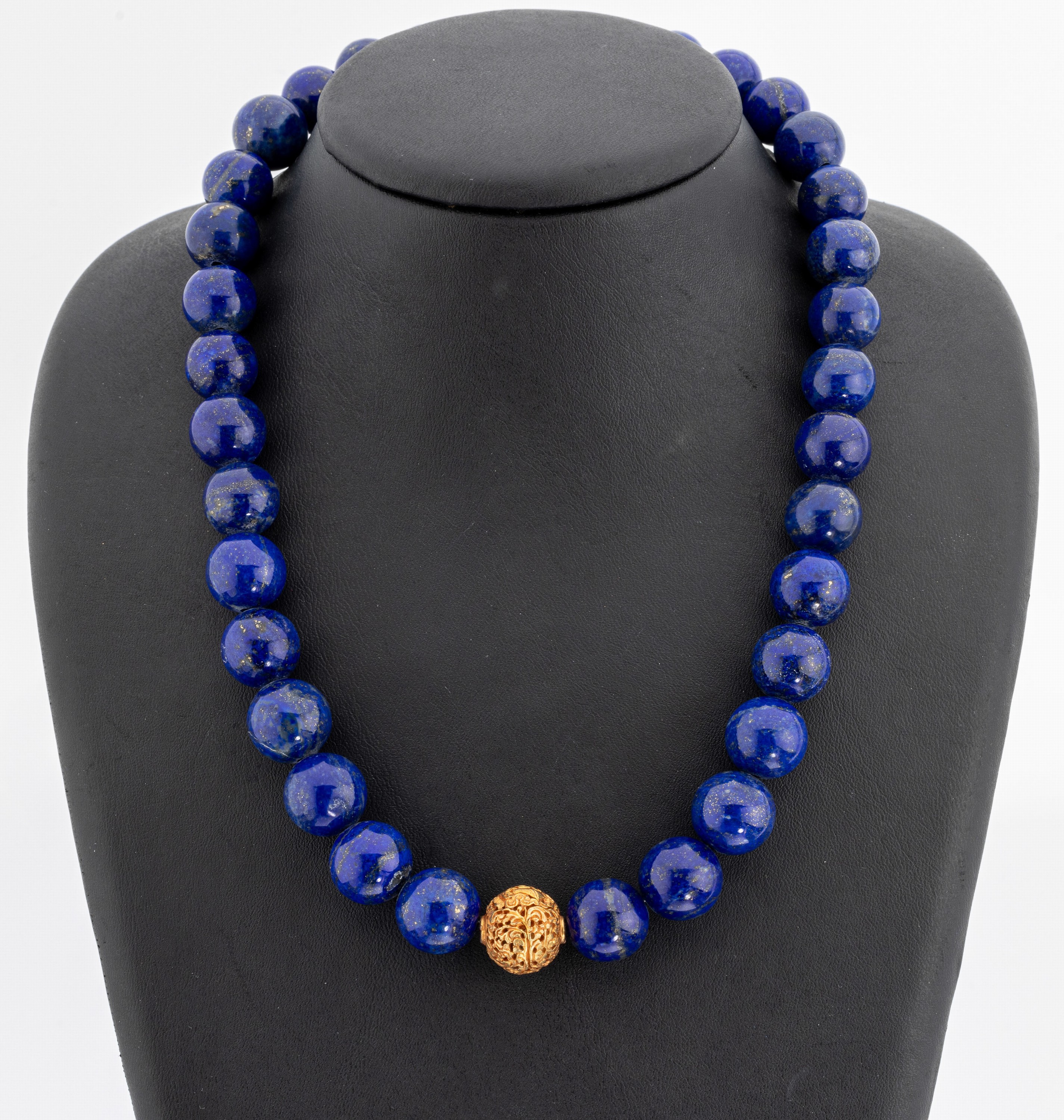 Lapislazuli-Collier, im Verlauf Lapislazuli-Kugeln, D. ca. 11.3-13.9 mm, Mittelteil durchbrochen gearbeitete Kugel, verg., L. ca. 46 cm, S-Schließe ...