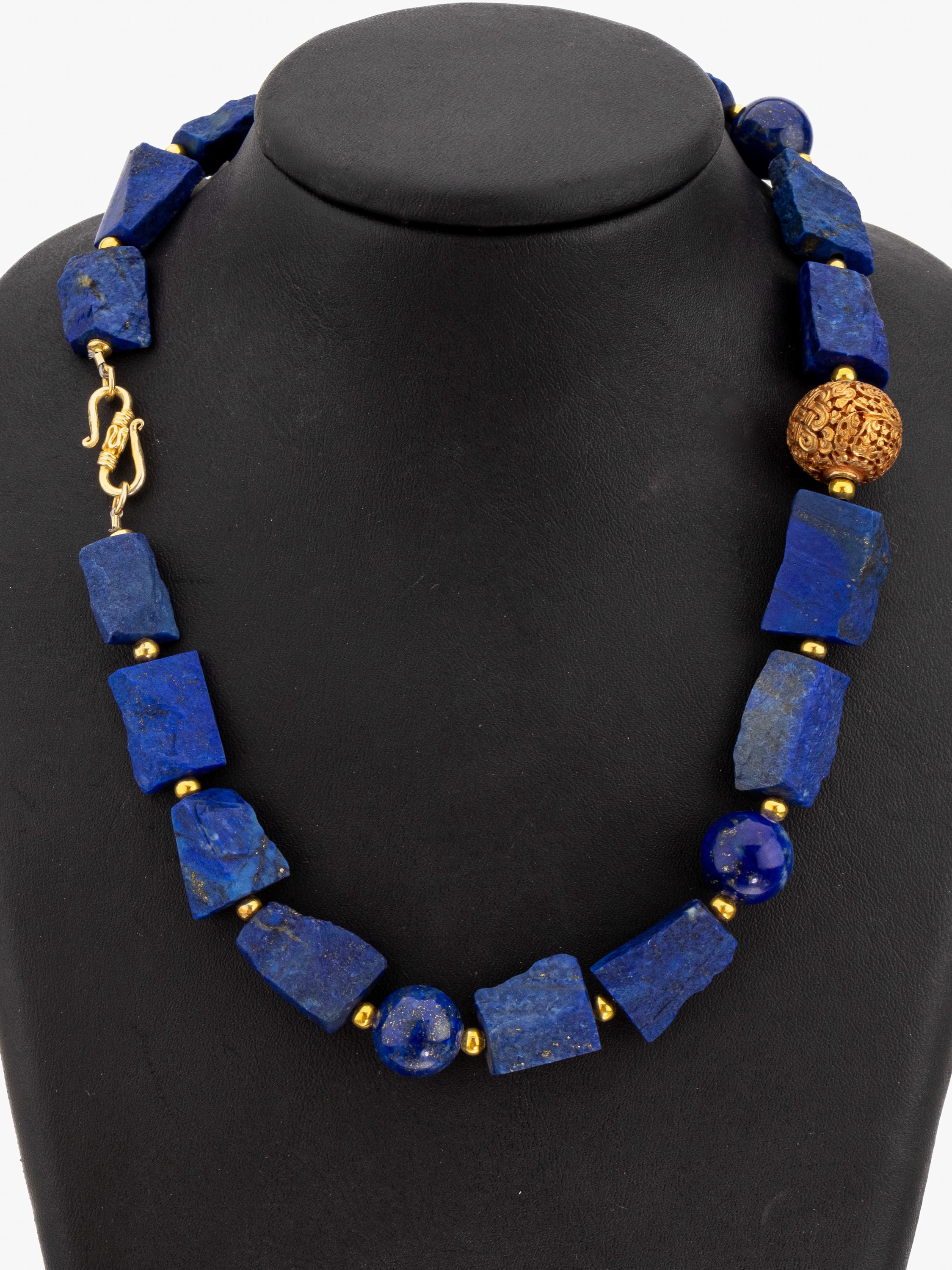 Lapislazuli-Collier, im Verlauf Lapislazuli-Rohsteine in versch. Grössen und Formen, 4 pol. Kugeln, Mittelteil durchbrochen gearbeitete Kugel, ...