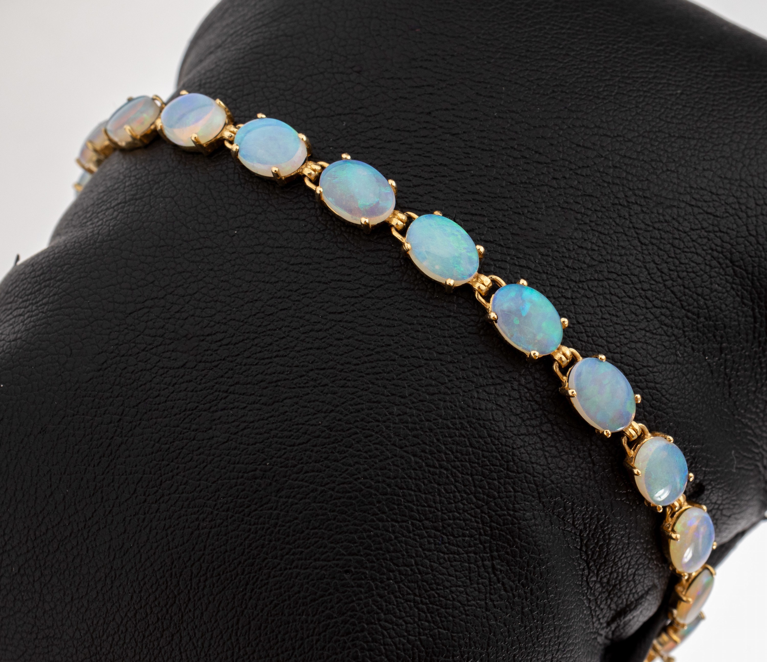 14 kt Gold Opal-Armband, GG 585/000, 19 ovale Opalcabochons zus. ca. 11.0 ct, L. ca. 18 cm, Kastenschloss mit Sicherheitsacht und -kettchen, ca. 7.1 ...