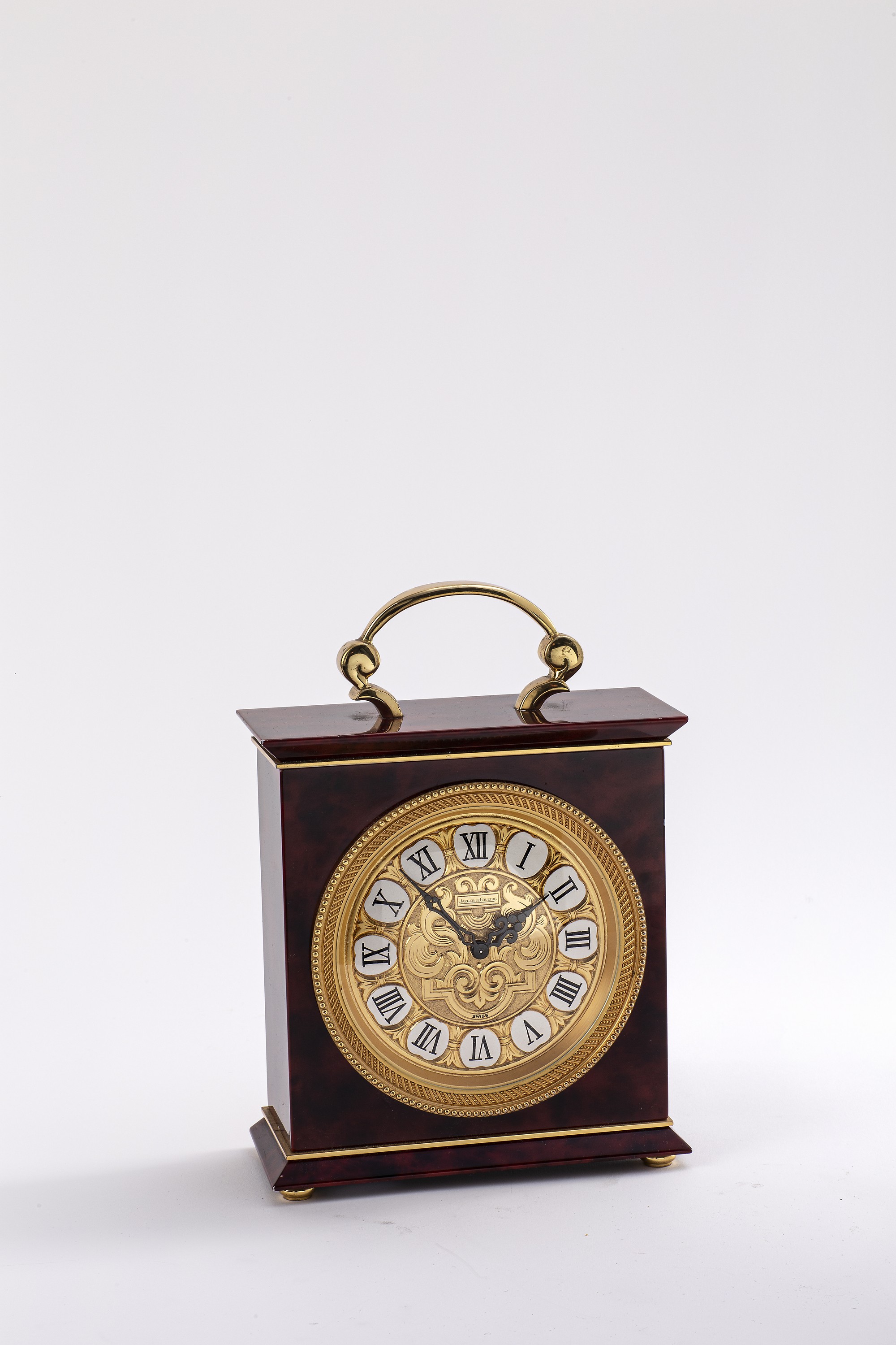 Jaeger-LeCoultre Tischuhr mit 1/2- Stundenschlag im Chinalack-Gehäuse Referenz 5507, Schweiz um 1960, rot marmoriert. Geh. m. Tragegriff, massive ...
