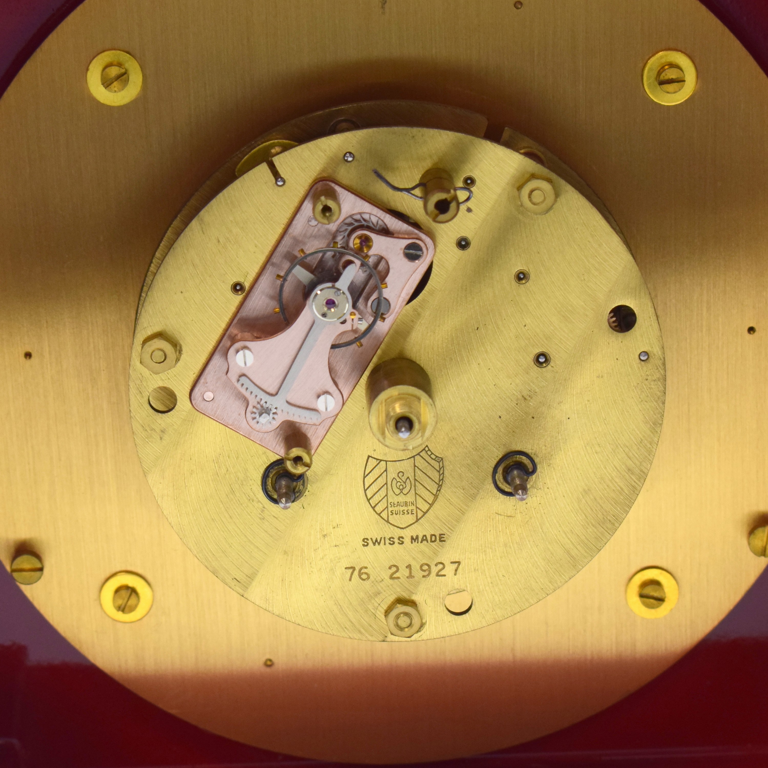 Detail f: Jaeger-LeCoultre Tischuhr mit 1/2- Stundenschlag im Chinalack-Gehäuse Referenz 5507, Schweiz um 1960, rot marmoriert. Geh. m. Tragegriff, massive ...