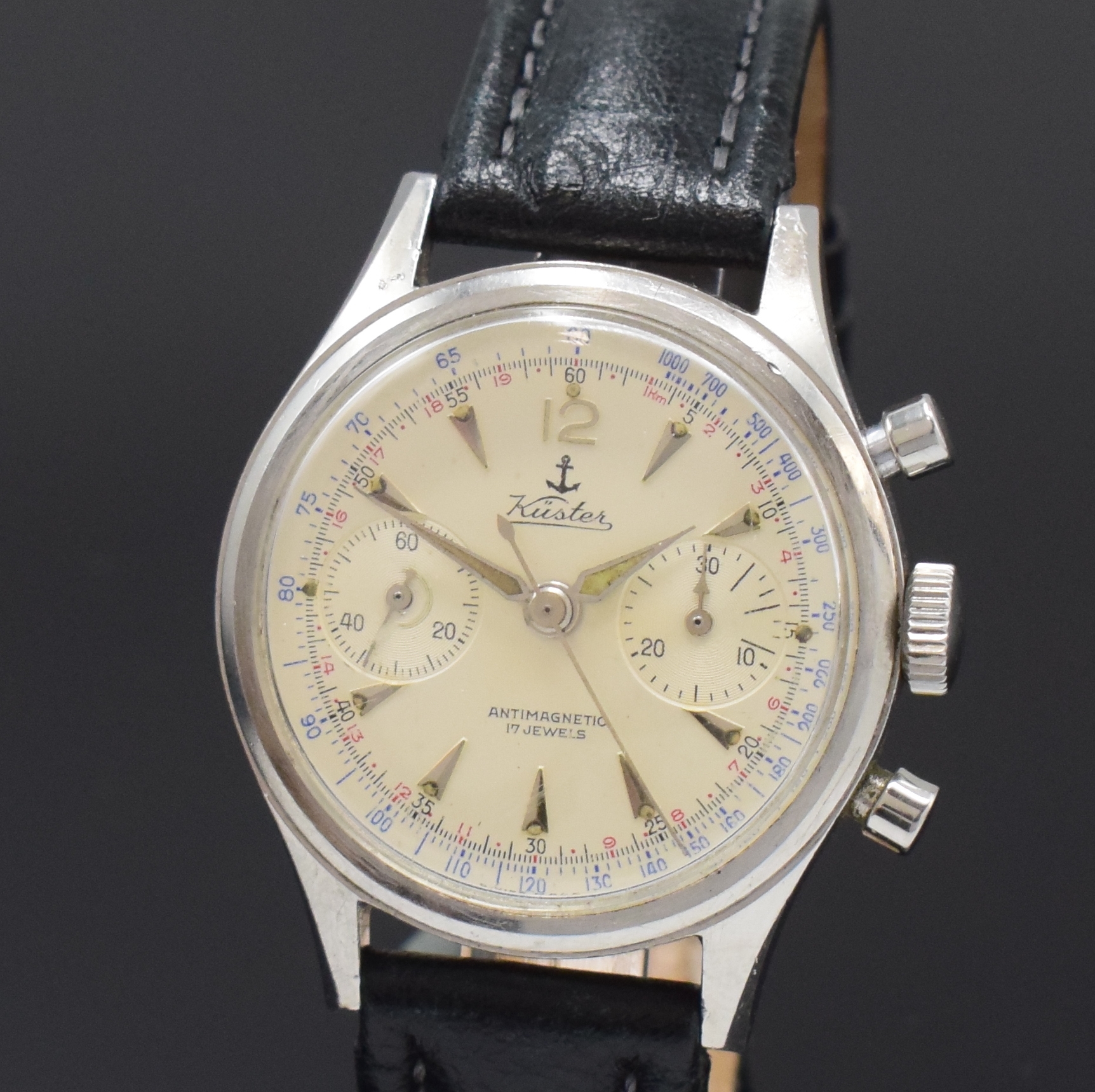 Detail a: KSTER Herrenchronograph in Stahl, Schweiz um 1960, Handaufzug, Boden verschr., silb. Zifferbl. m. silb. Std.-Ind., Leuchtzeiger, 30 Min.-Zähler, kl. ...