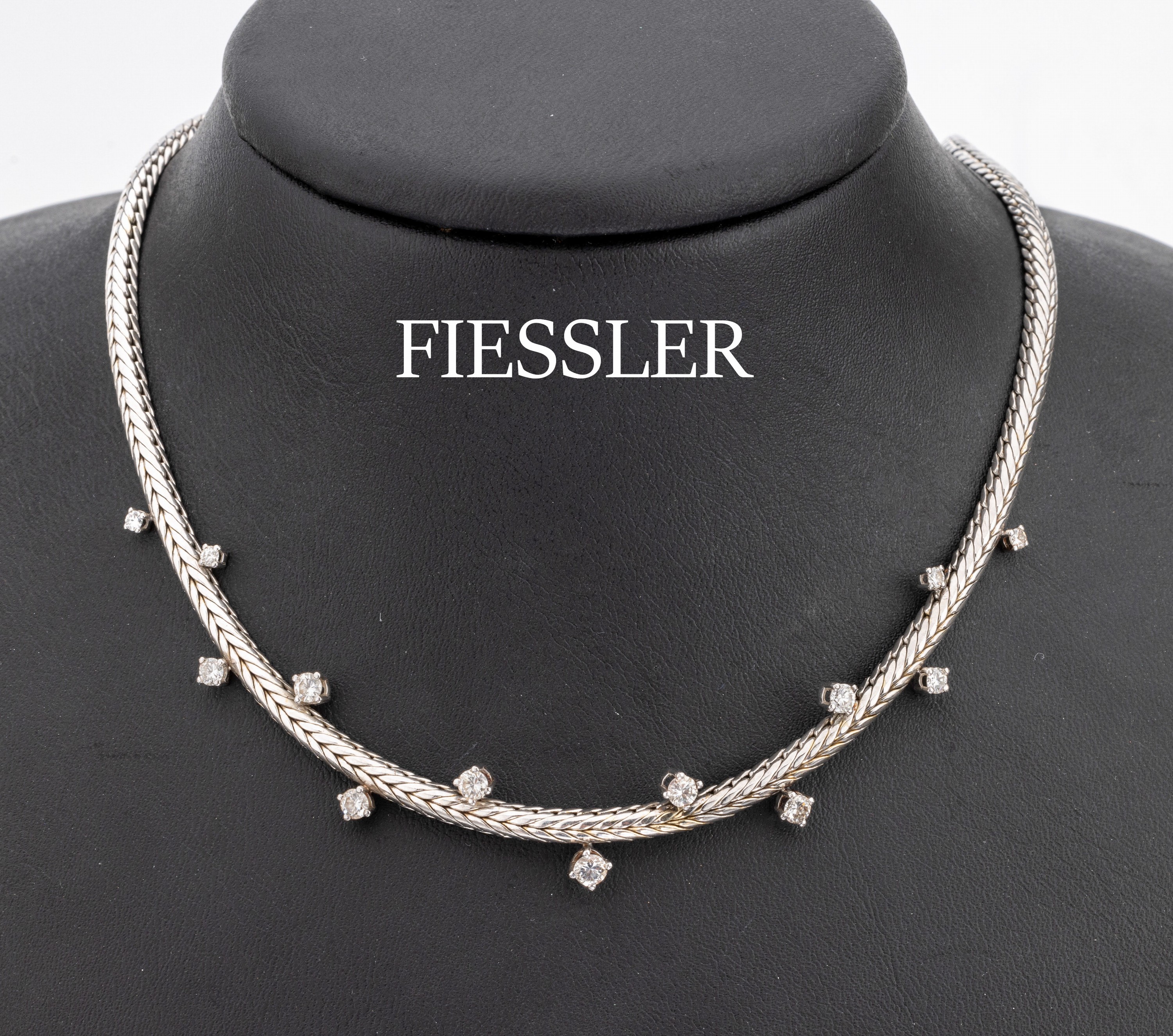18 kt Gold Brillant-Collier, WG 750/000, Mittelteil mit 13 gegenüberliegende Brillantenzus. ca. 1.00 ct Weiß/si, Zopfkette, L. ca. 42cm, ...