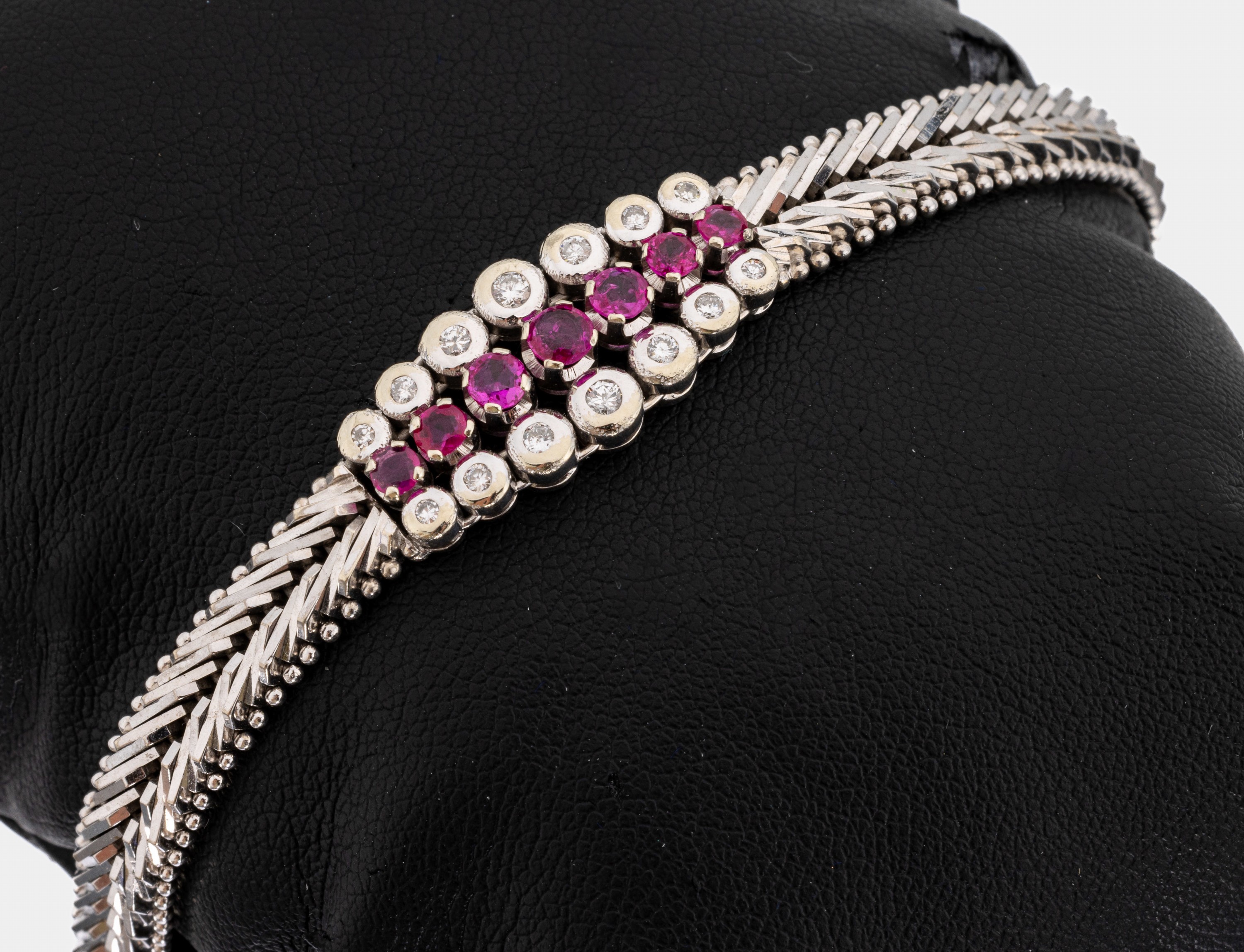 14 kt Gold Rubin-Brillant-Armband, WG 585/000, Mittelteil mit 7 rundfacett. Rubine zus. ca. 0.50 ct, umgeben von 14 Brillanten zus. ca. 0.22 ct ...