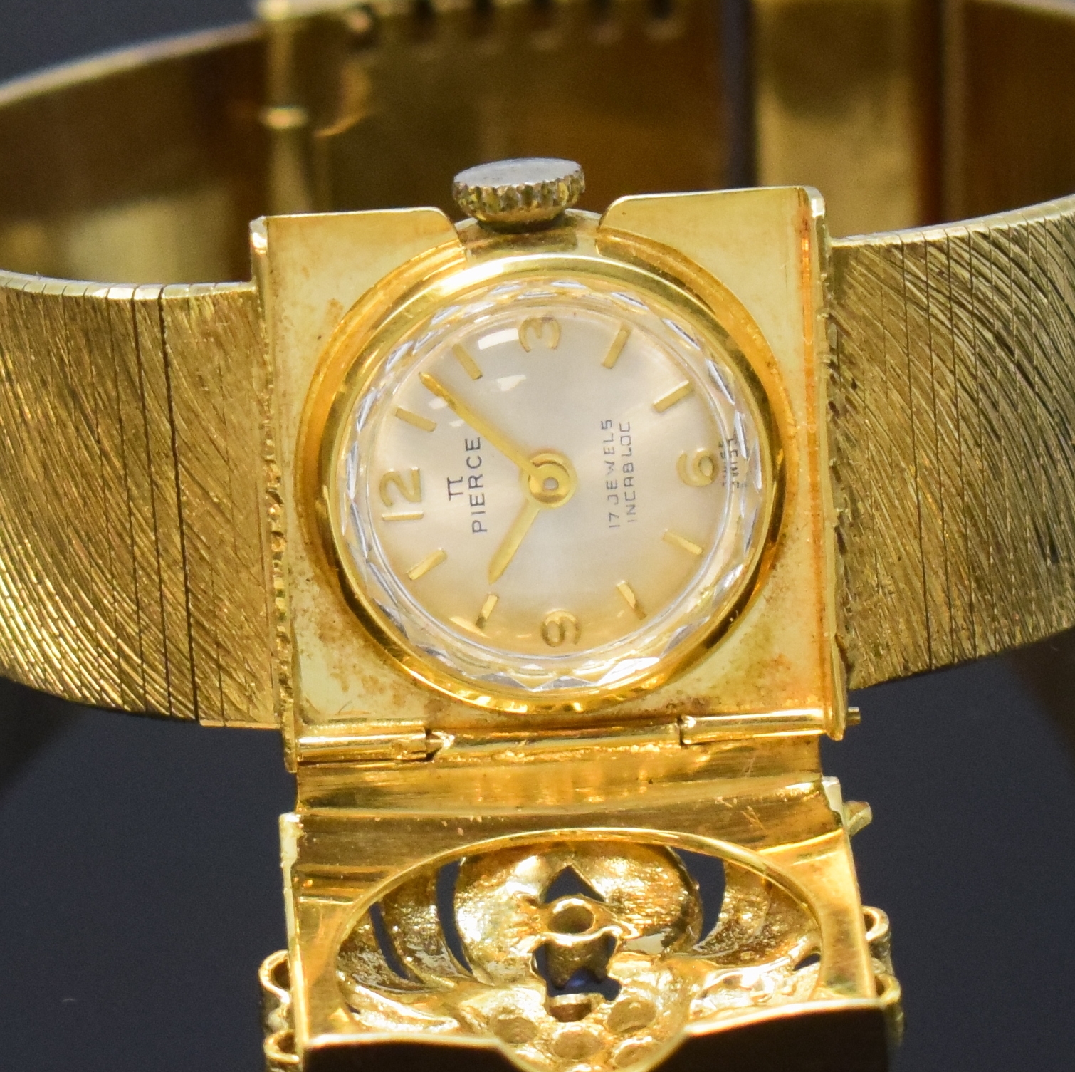Detail a: PIERCE Damenschmuckuhr in GG 585/000, Schweiz um 1960, Handaufzug, quadrat. Geh. m. anges. strukturiertem Goldband, floral verzierter u. durchbr. ...