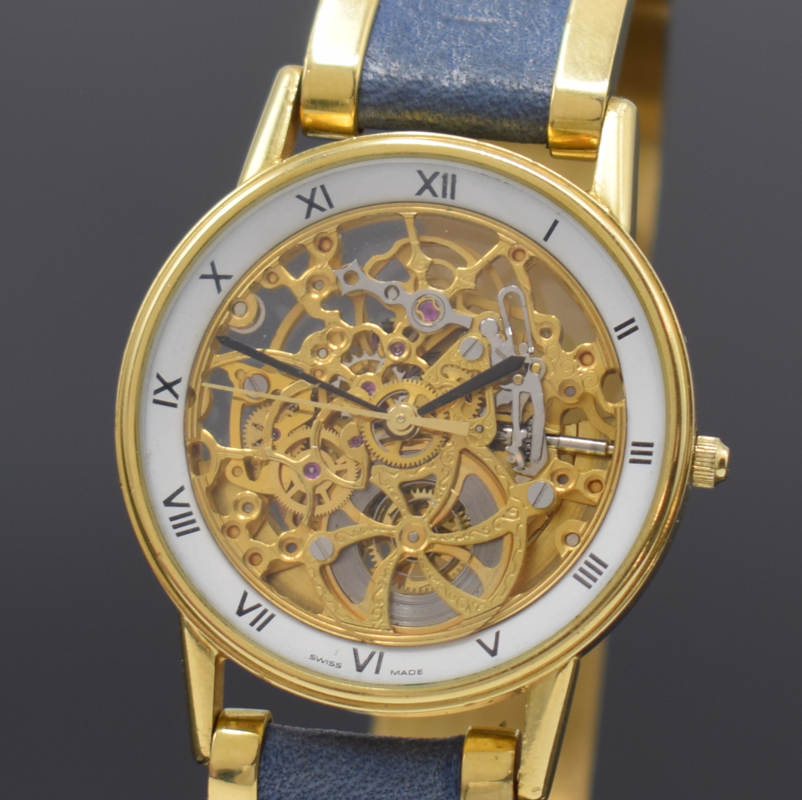 Detail a: Feine, skelettierte Armbanduhr in GG 750/000 an GG 750/000 Armspange, Automatik, 1990er Jahre, beids. vergl., Boden aufgedr., weisser Ziffernring m. ...