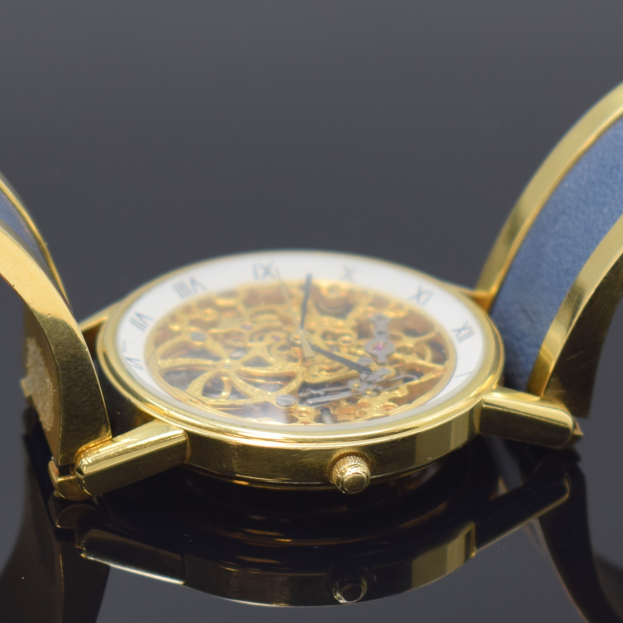 Detail d: Feine, skelettierte Armbanduhr in GG 750/000 an GG 750/000 Armspange, Automatik, 1990er Jahre, beids. vergl., Boden aufgedr., weisser Ziffernring m. ...