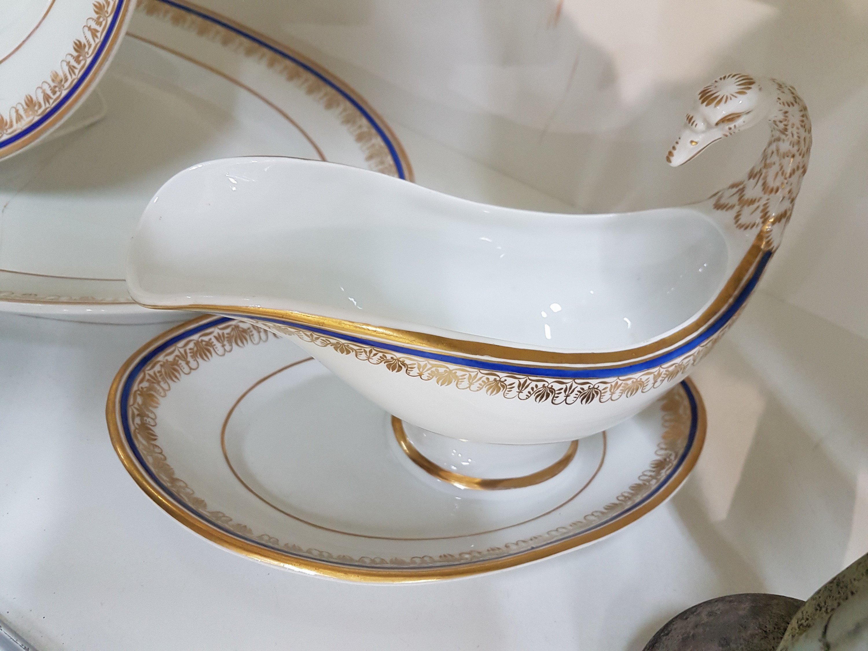 Detail b: Sauciere und zwei Platten, KPM, 1837-1870, Porzellan, Rand mit blauem Band und Goldfaden, Rankendekor in Gold, Sauciere mit Schwanenhenkel 1837-1844, ...