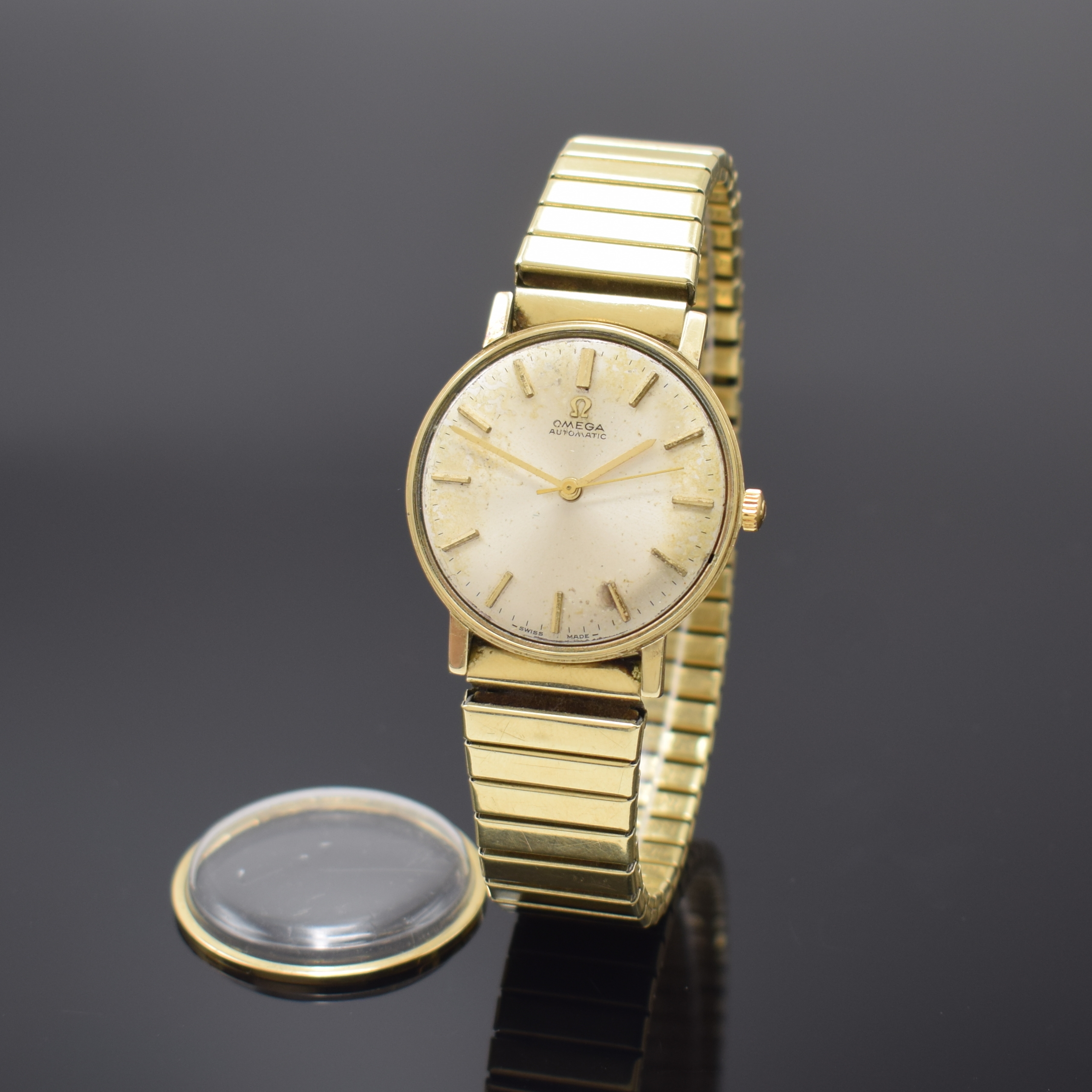 OMEGA Armbanduhr Referenz 161009 an neutralem Flexband in GG 585/000, Schweiz um 1964, Automatik, 3-tlg. Goldgeh., Boden u. Glasrand aufgedr., silb. ...