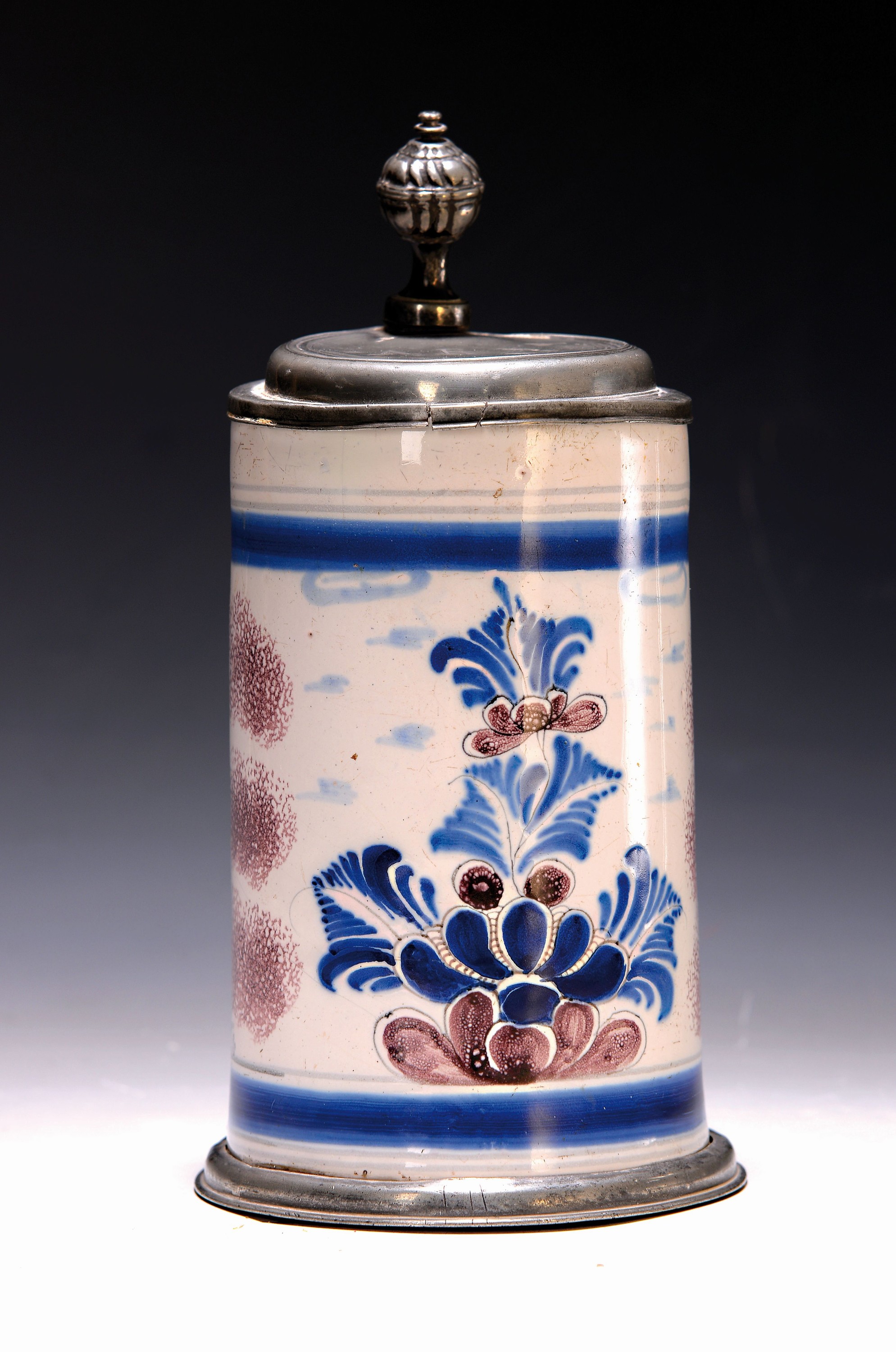 Walzenkrug, Bayreuth um 1750, zylindrischer Korpus auf Zinnfuß, helle Engobe mit blauer und manganfarbener Bemalung, seitlich im sog. ...