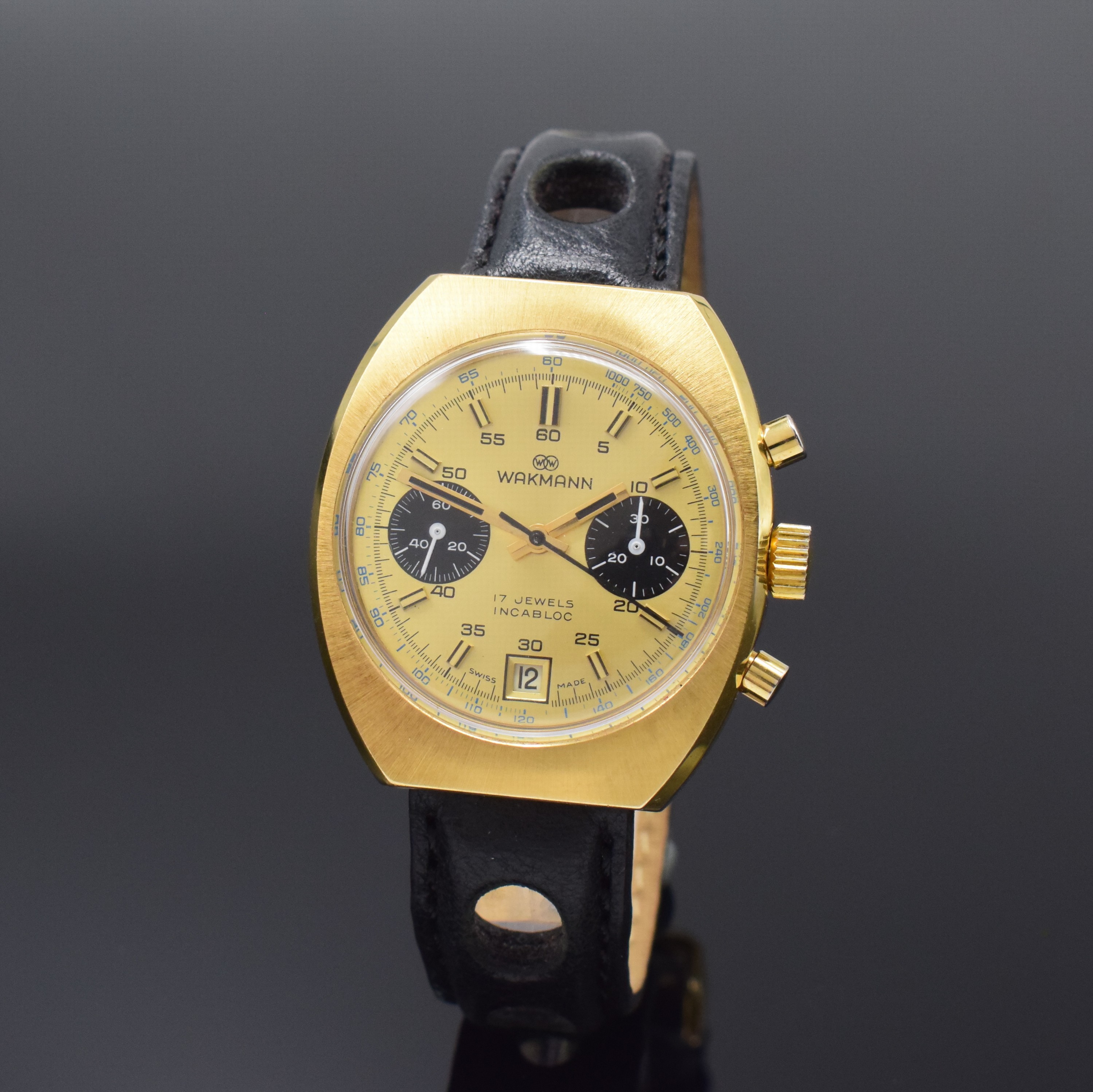 WAKMANN / GIGANDET Herrenarmbanduhr mit Chronograph, Schweiz um 1970, Handaufzug, verg. Geh., Stahlboden verschr., gold. Zifferbl., schwarz. ...