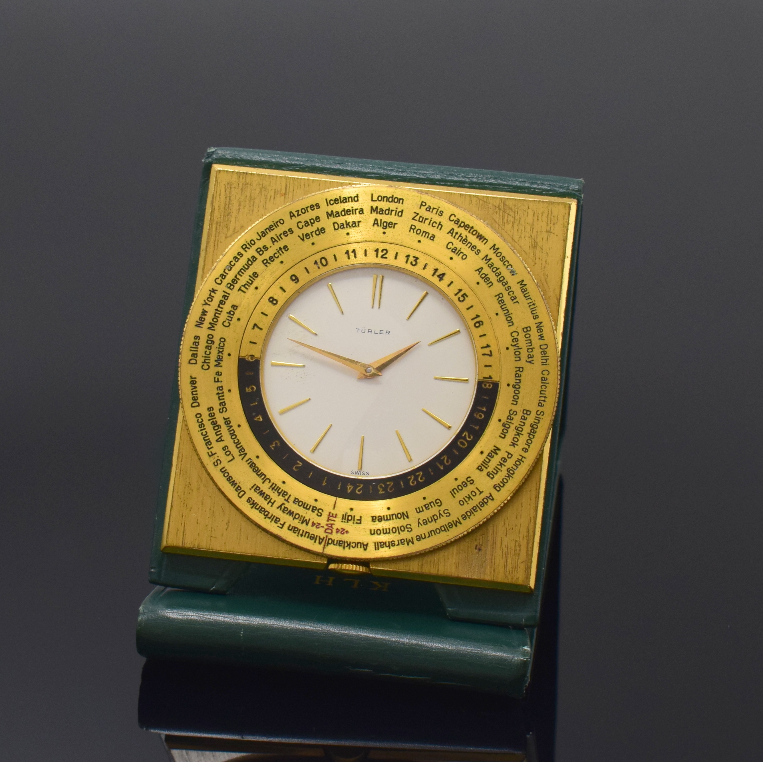 TÜRLER Reiseuhr mit Weltzeitanzeige, Schweiz um 1960, Handaufzug, verg. Gehäuse im Lederetui, drehbare Lünette m. Weltstädten und 24-Std.-Skala, ...