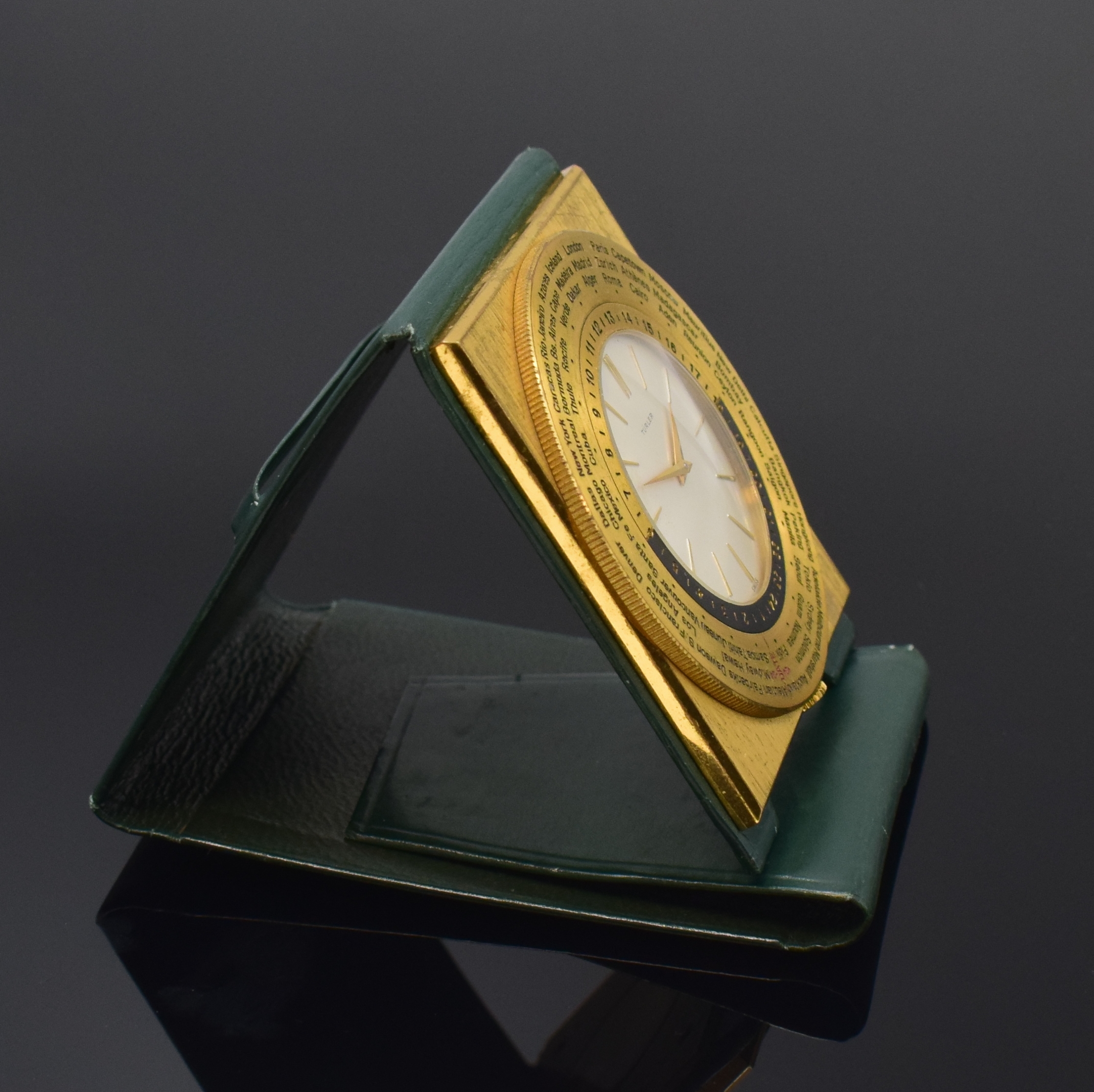 Detail b: TÜRLER Reiseuhr mit Weltzeitanzeige, Schweiz um 1960, Handaufzug, verg. Gehäuse im Lederetui, drehbare Lünette m. Weltstädten und 24-Std.-Skala, ...