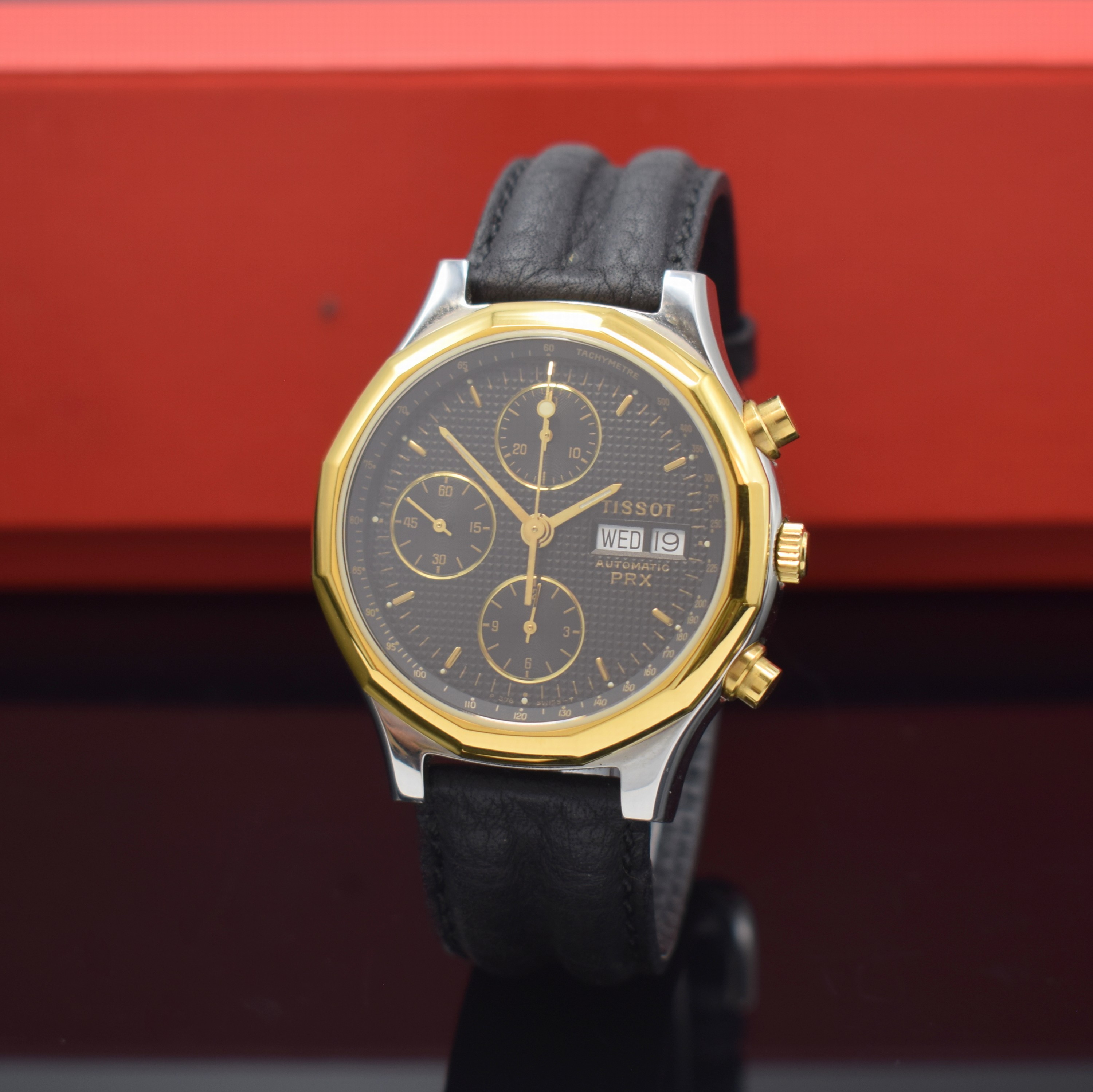 TISSOT PRX Armbandchronograph, Schweiz um 1990, Automatik, Stahlgeh. m. verg. 12-eckiger Lünette, Boden verschr., schwarz. Waffel- Zifferbl., gold. ...