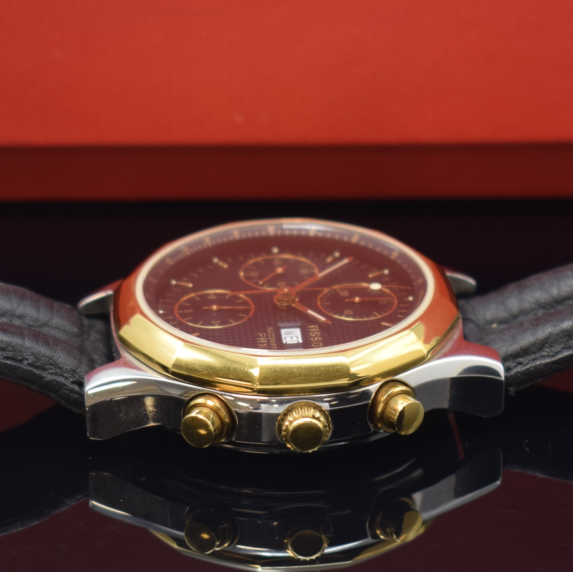 Detail c: TISSOT PRX Armbandchronograph, Schweiz um 1990, Automatik, Stahlgeh. m. verg. 12-eckiger Lünette, Boden verschr., schwarz. Waffel- Zifferbl., gold. ...